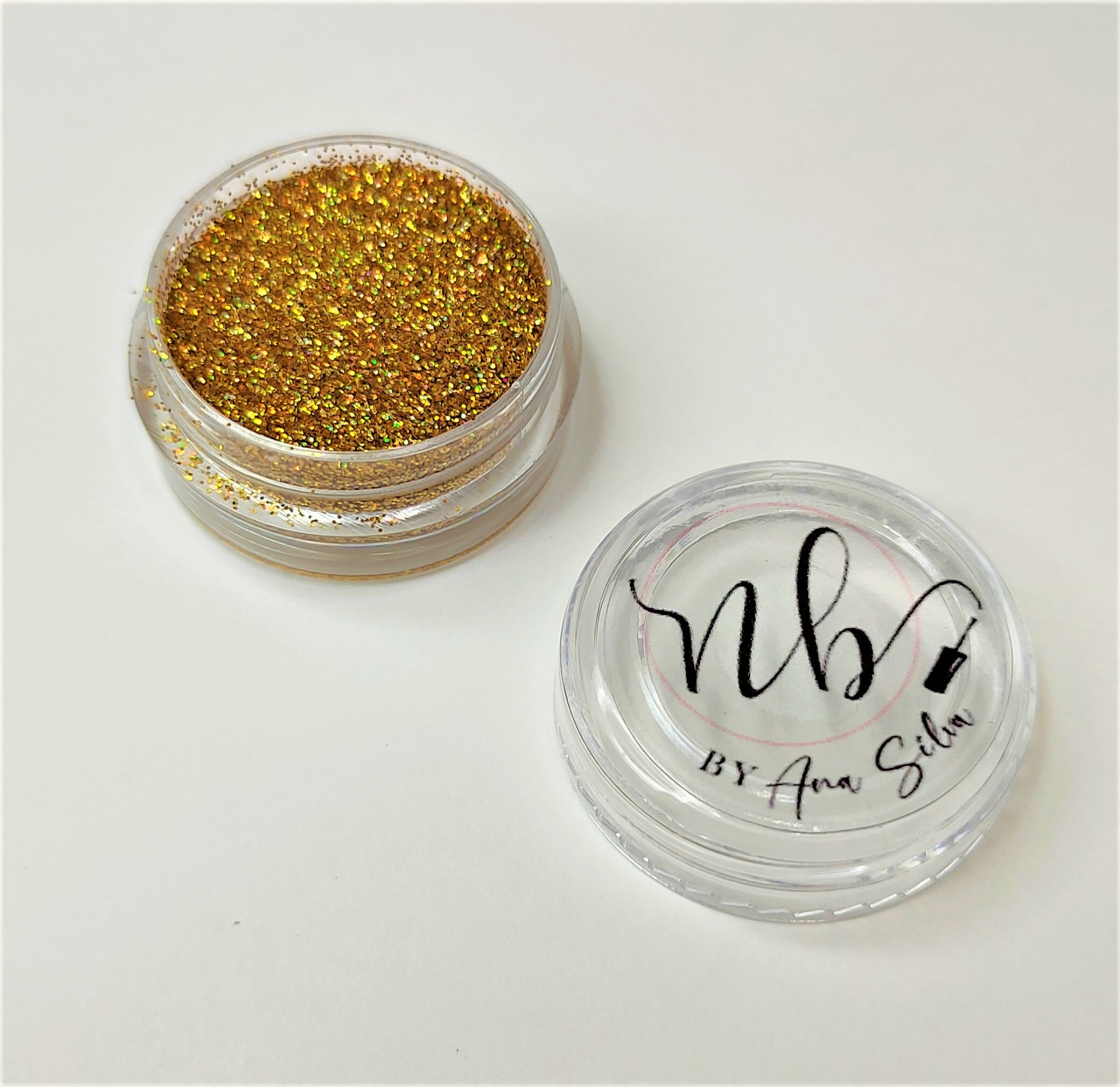 Frasco transparente com brilho dourado holográfico e tampa com escrita nb by Ana Silva