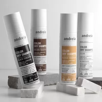 Quatro frascos de champô seco Andreia Professional em cores variadas sobre blocos cinza e branco