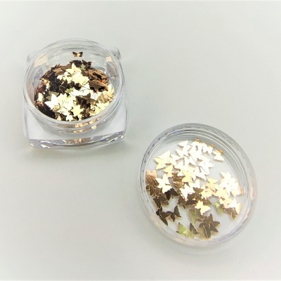 Dois recipientes transparentes com adesivos metálicos dourados e prateados em forma de folhas.