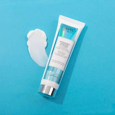 Tubo de creme APIS Professional azul e branco sobre fundo azul com creme espalmado