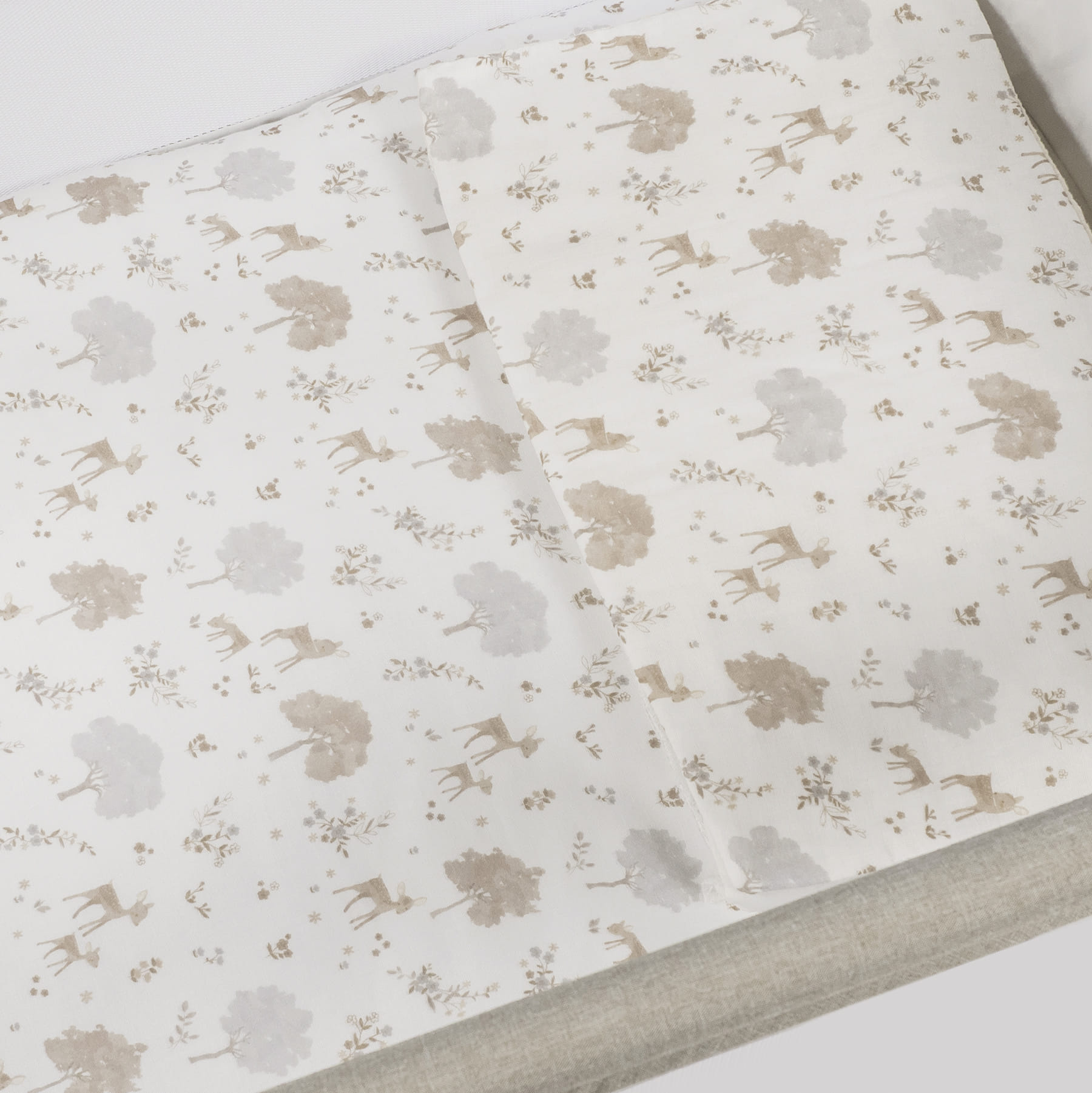 roupa de cama branca com padrão de veados e árvores em bege e cinza