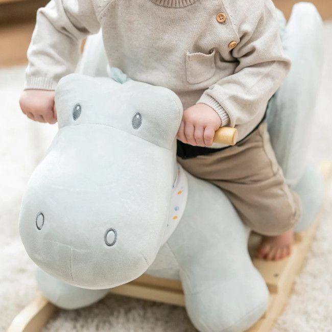 Cavalo de balanço de peluche azul com estrutura de madeira e criança sentada