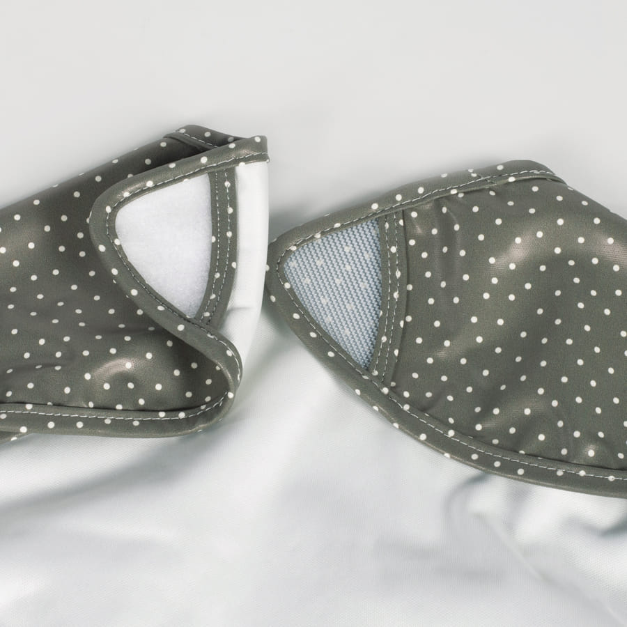 Luvas impermeáveis cinza com bolinhas brancas, uma aberta mostrando interior listrado azul e branco.