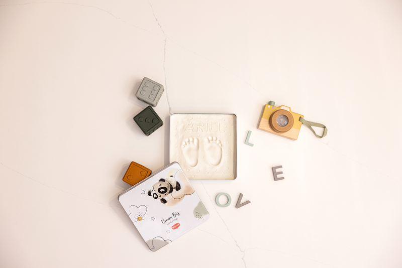 Moldes, blocos de silicone e brinquedos infantis dispostos sobre uma superfície clara com fissuras