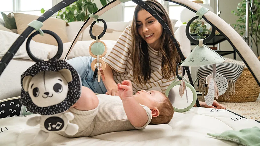 Tapete de atividades para bebé com arco preto e branco e brinquedos pendurados