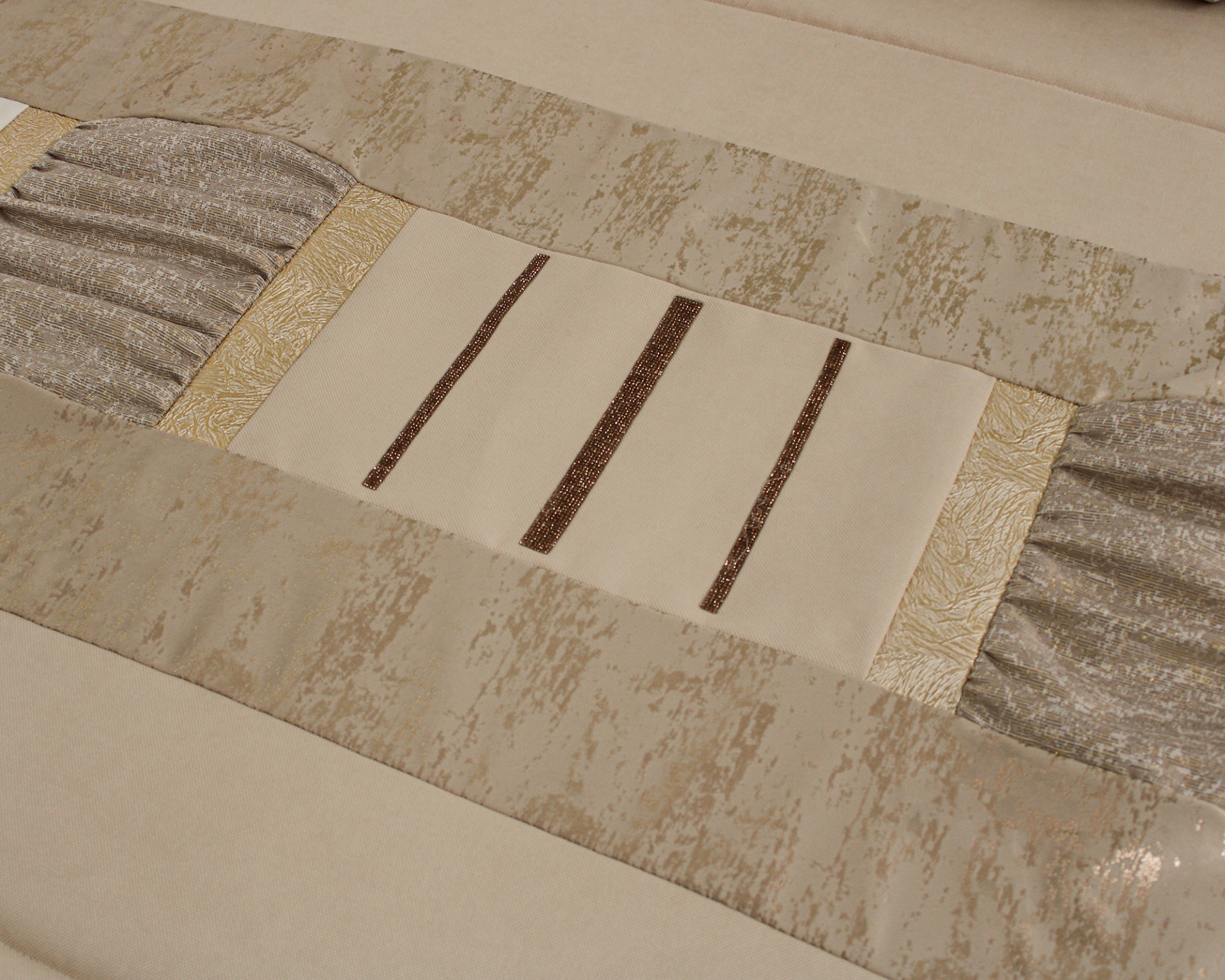 toalha de mesa bege com padrões castanhos e dourados