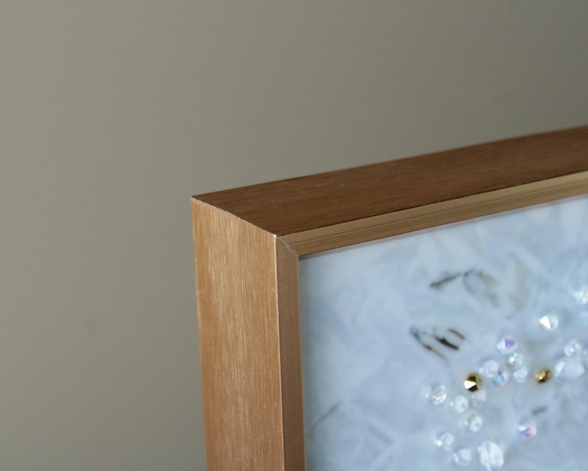 Moldura de madeira clara com arte abstrata protegida por vidro