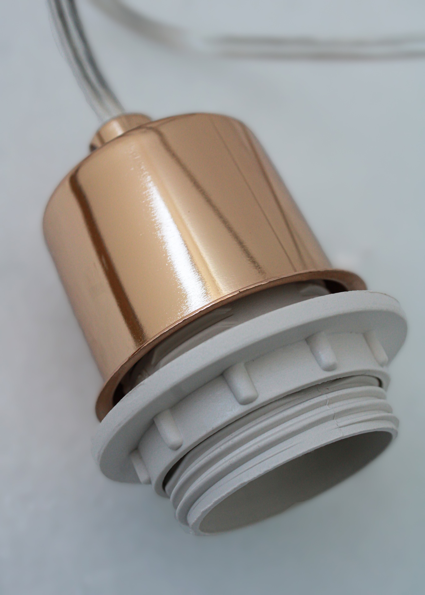 Suporte de lâmpada metálico cor cobre com base plástica branca e fios elétricos