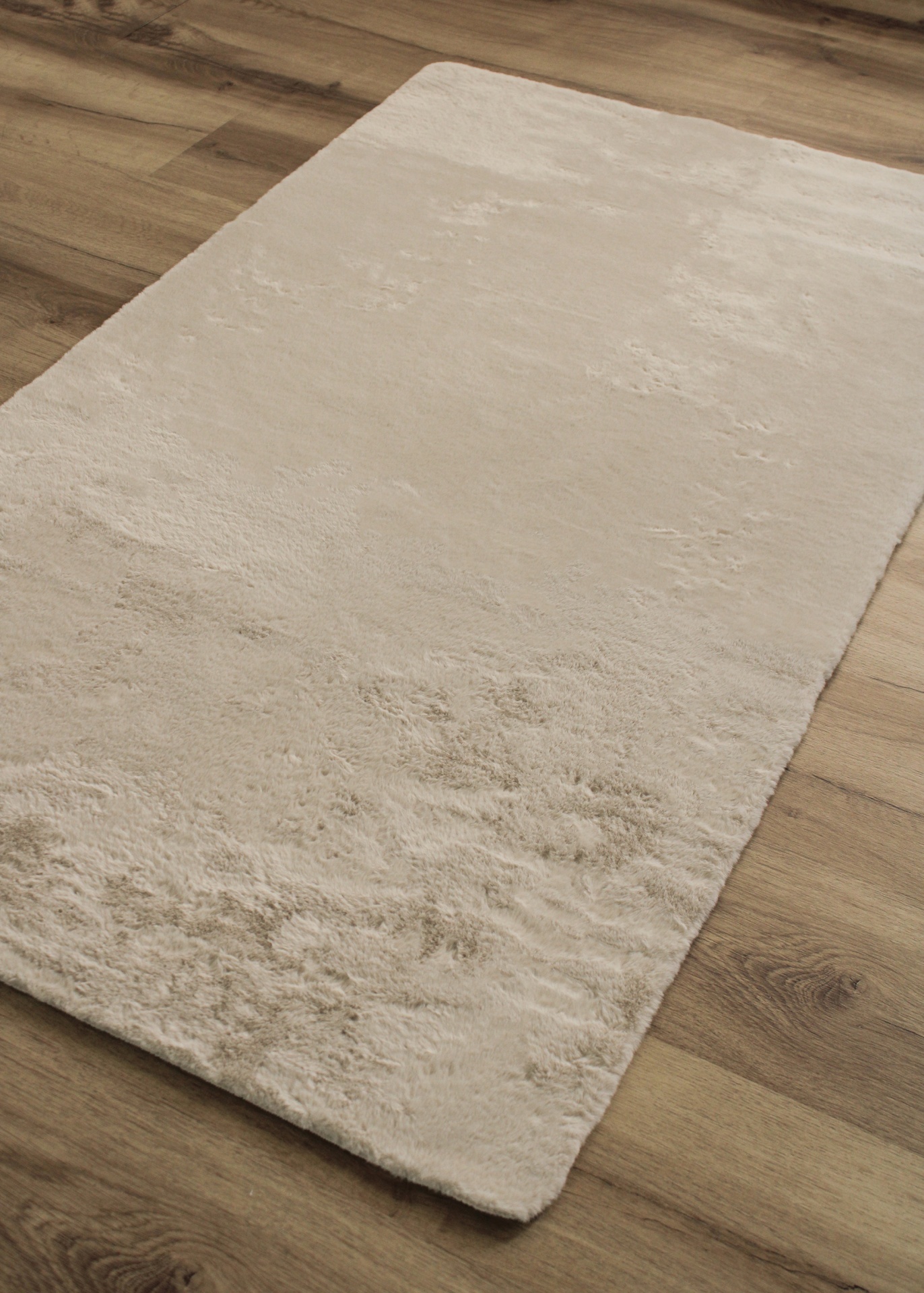 Tapete macio bege claro sobre chão de madeira clara