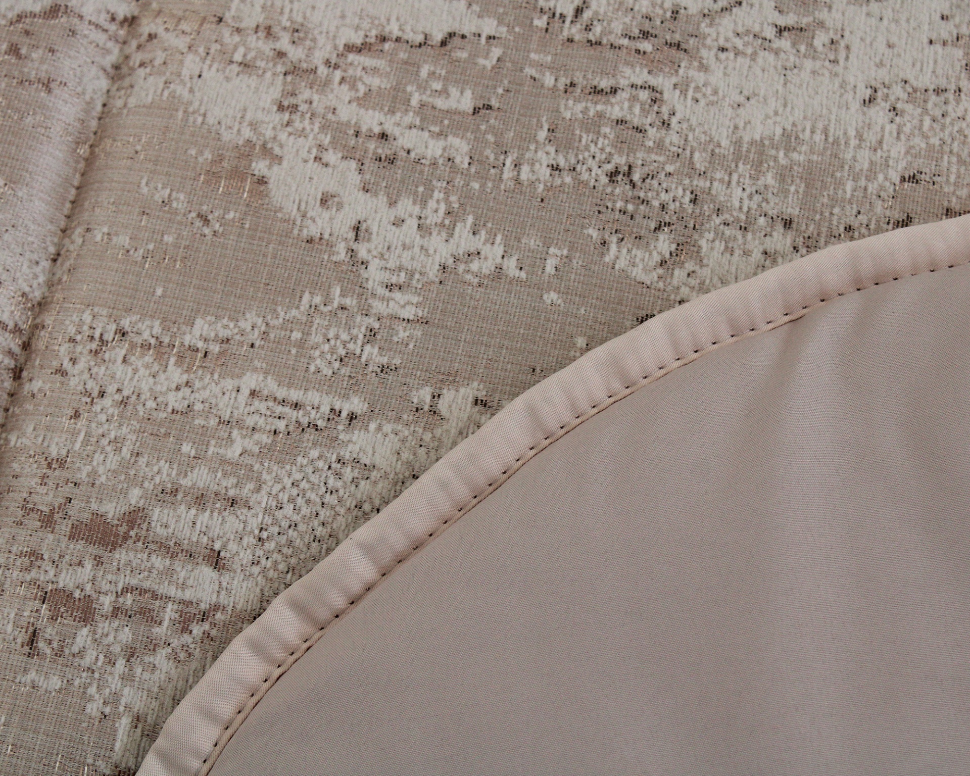 Tapete com dois tipos de tecido em tons bege claro e costura visível na borda