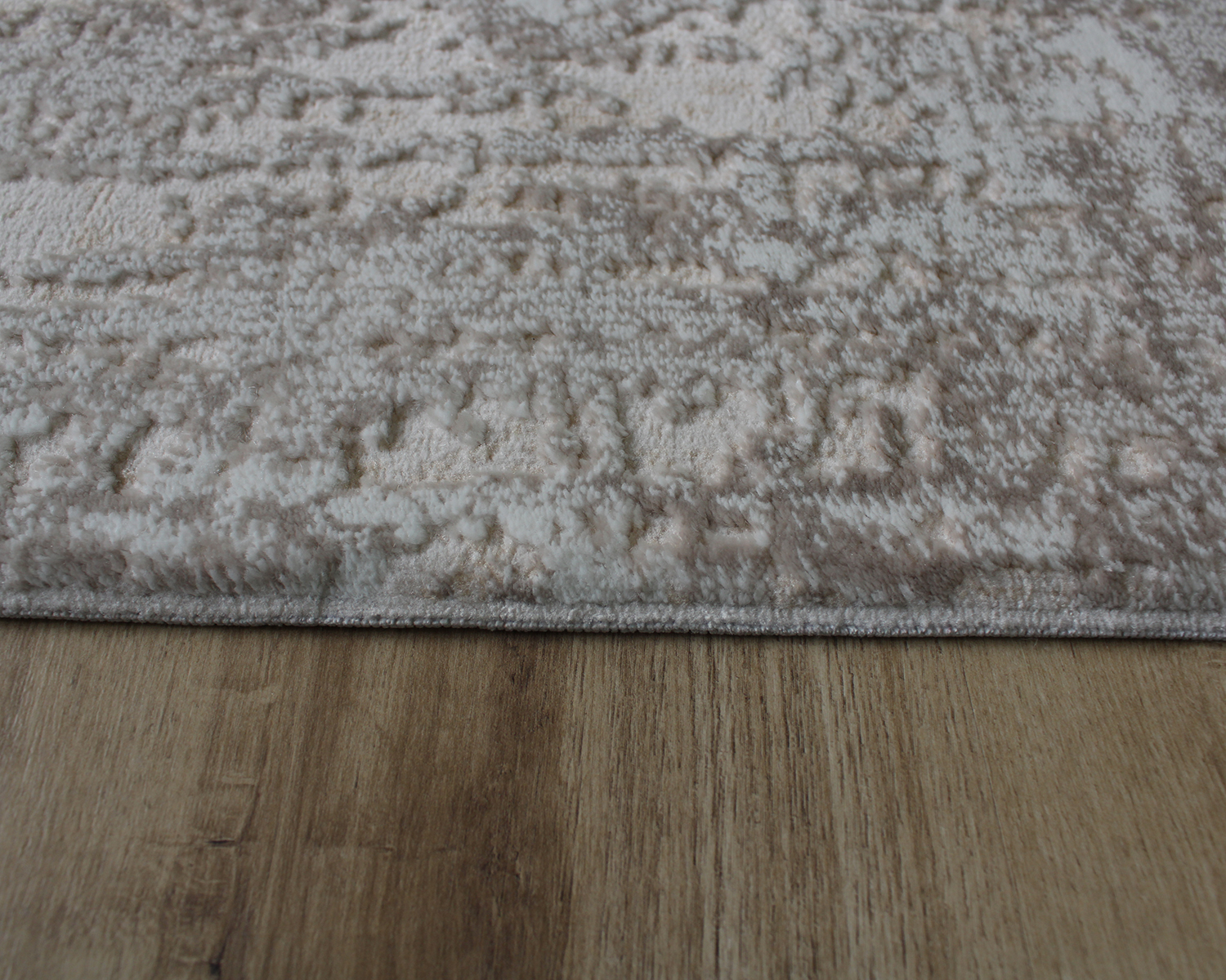 Tapete bege e cinza com padrão abstracto sobre chão de madeira clara