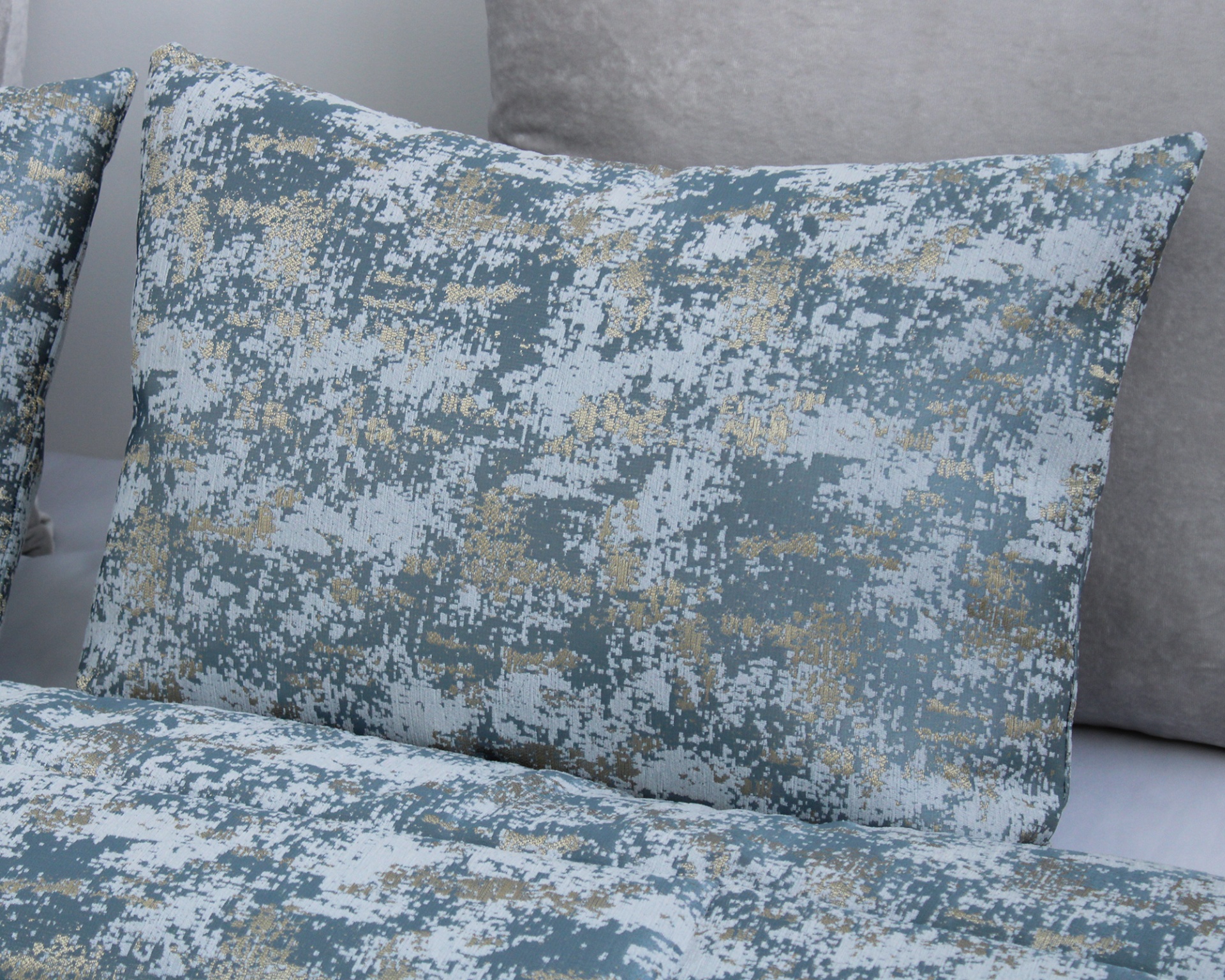 Almofada e edredão com padrão pixelado azul, branco e dourado