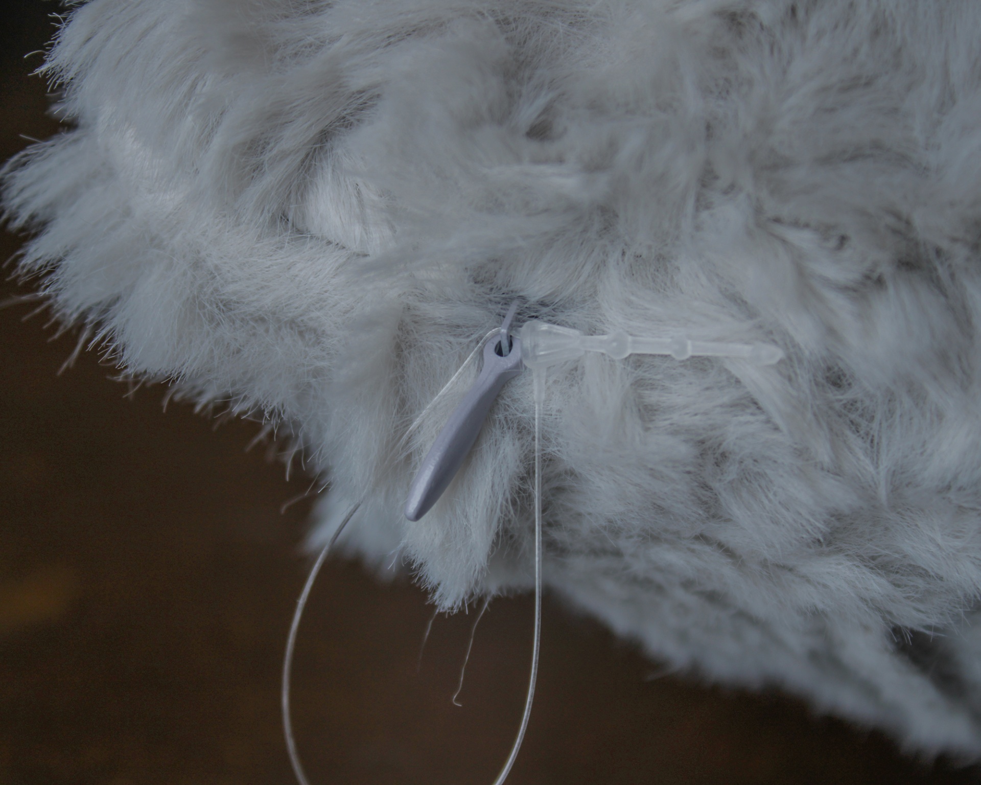 Produto peludo branco com etiqueta plástica