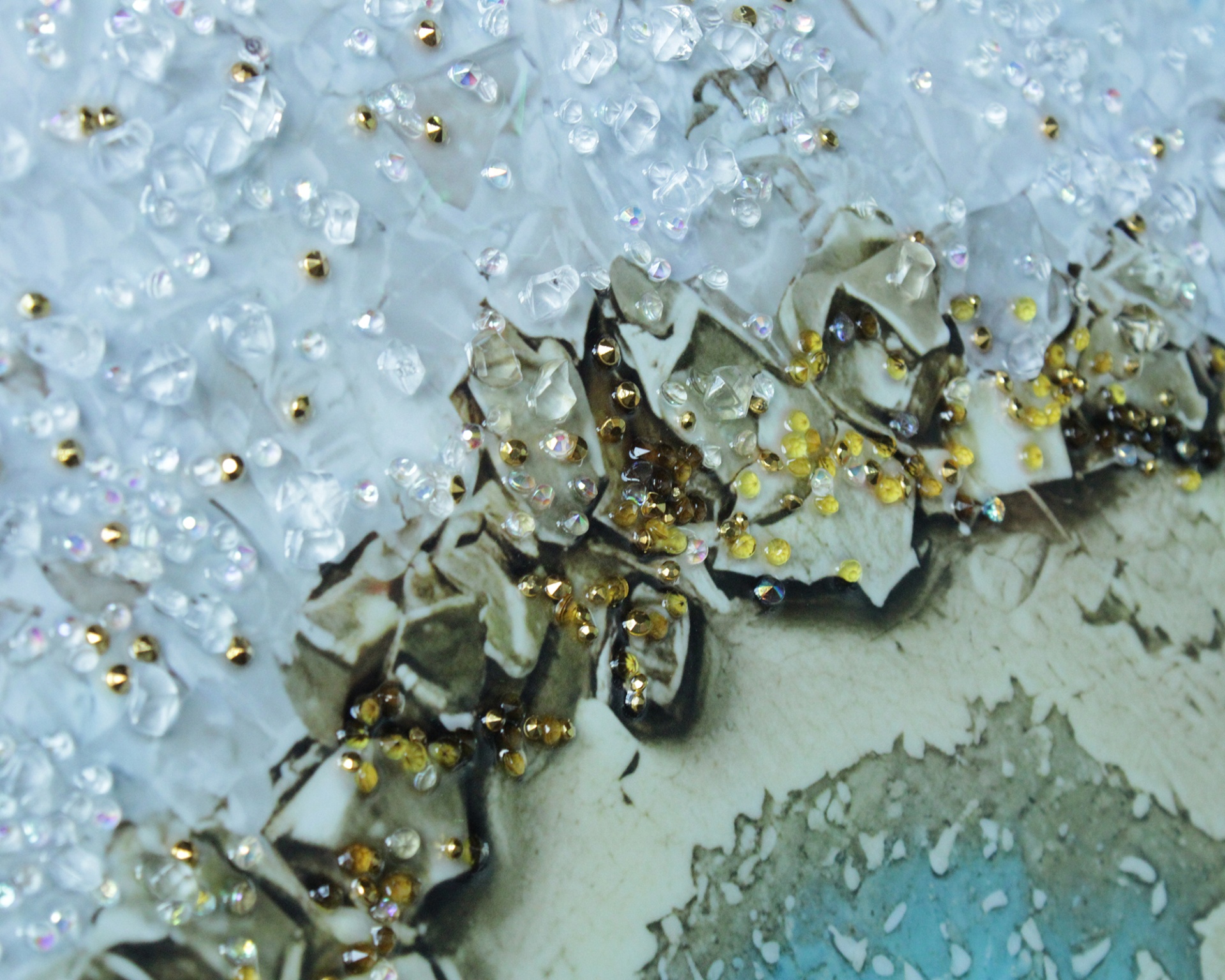 Cristais translúcidos brancos com pequenas esferas douradas em superfície texturizada