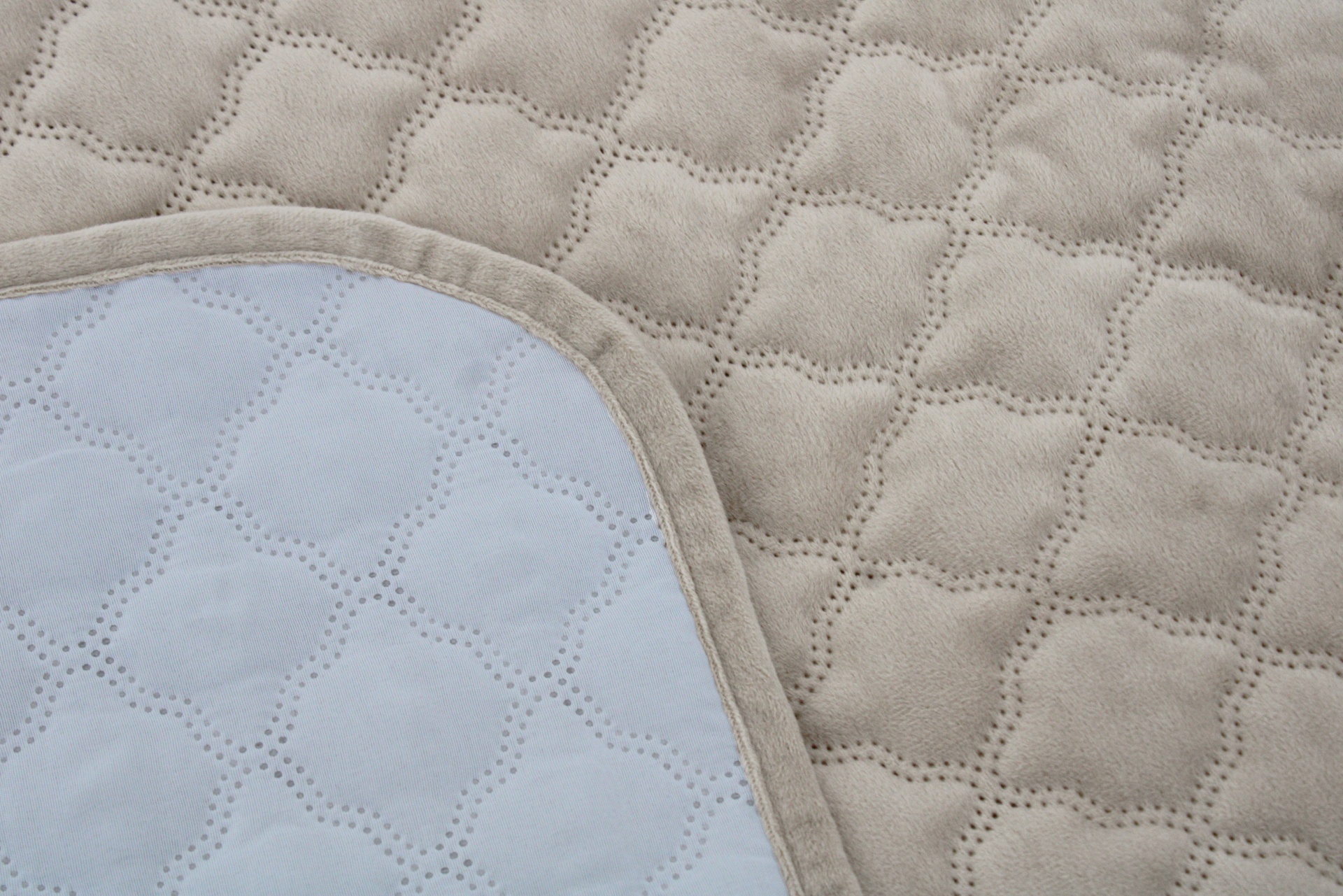 Colcha acolchoada bege com padrão quadrado e lado branco com acabamento em tecido bege