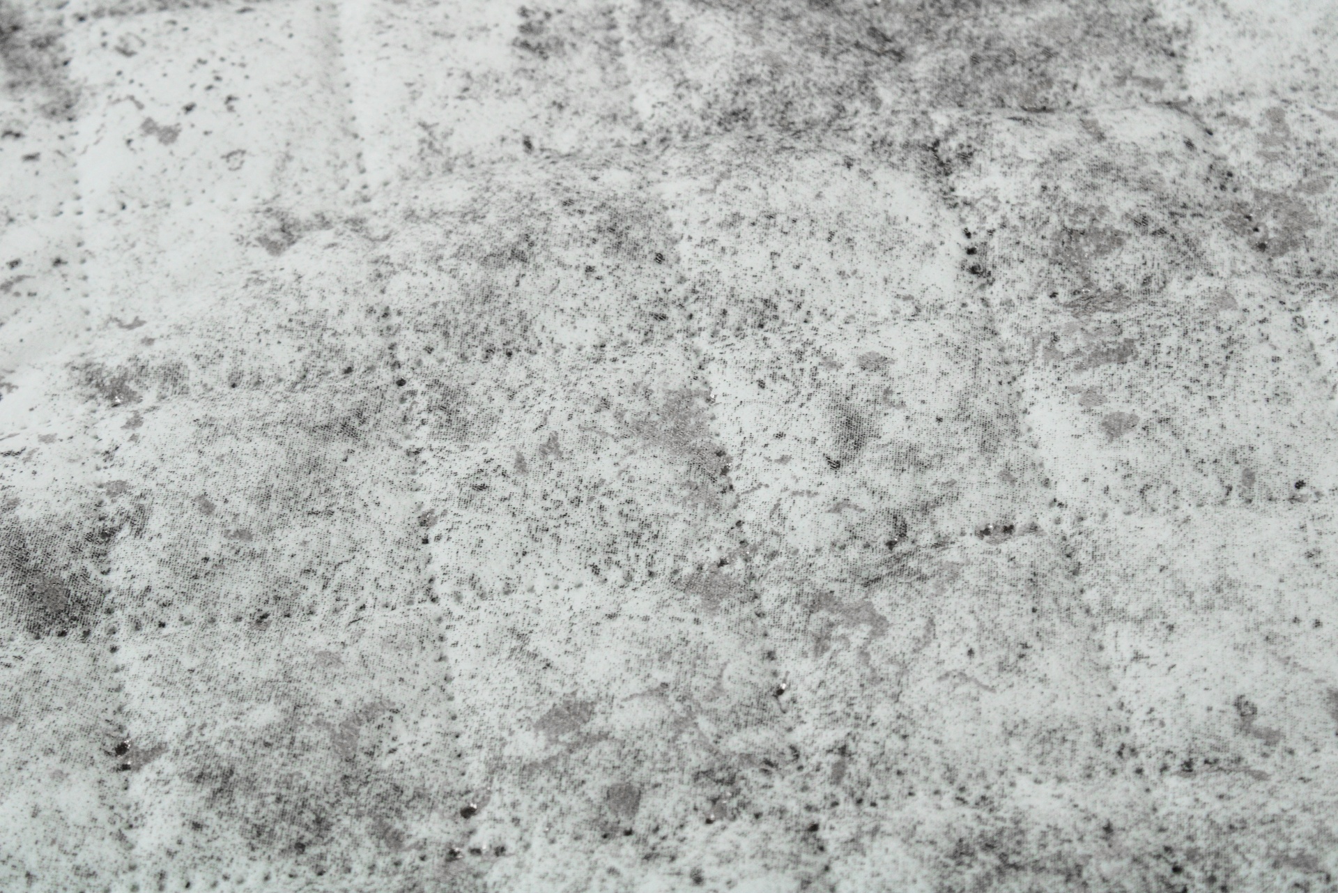 Superfície de pedra cinzenta com manchas pretas