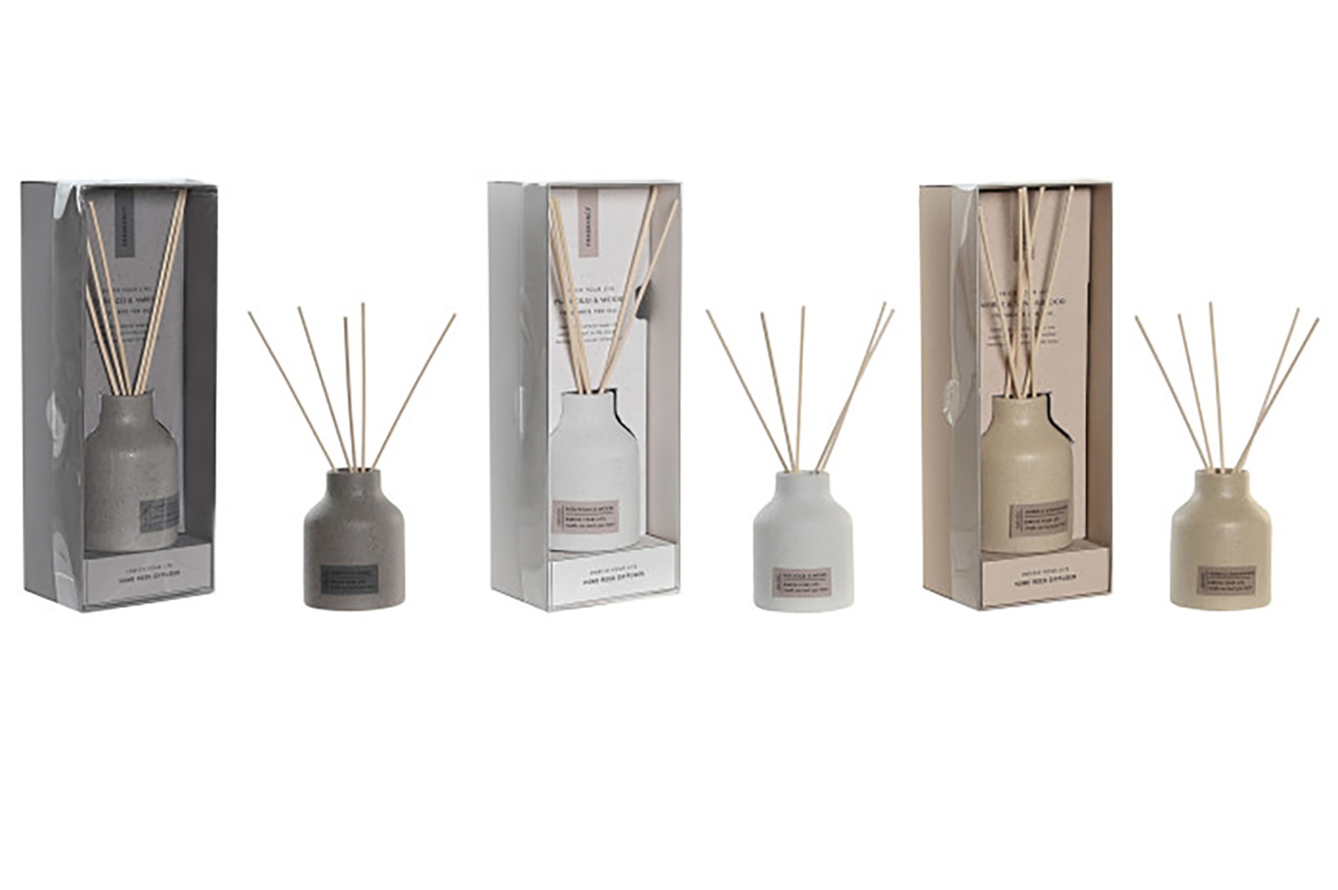 Três difusores de ambiente cerâmicos em cinza, branco e bege com paus de madeira e embalagens transparentes