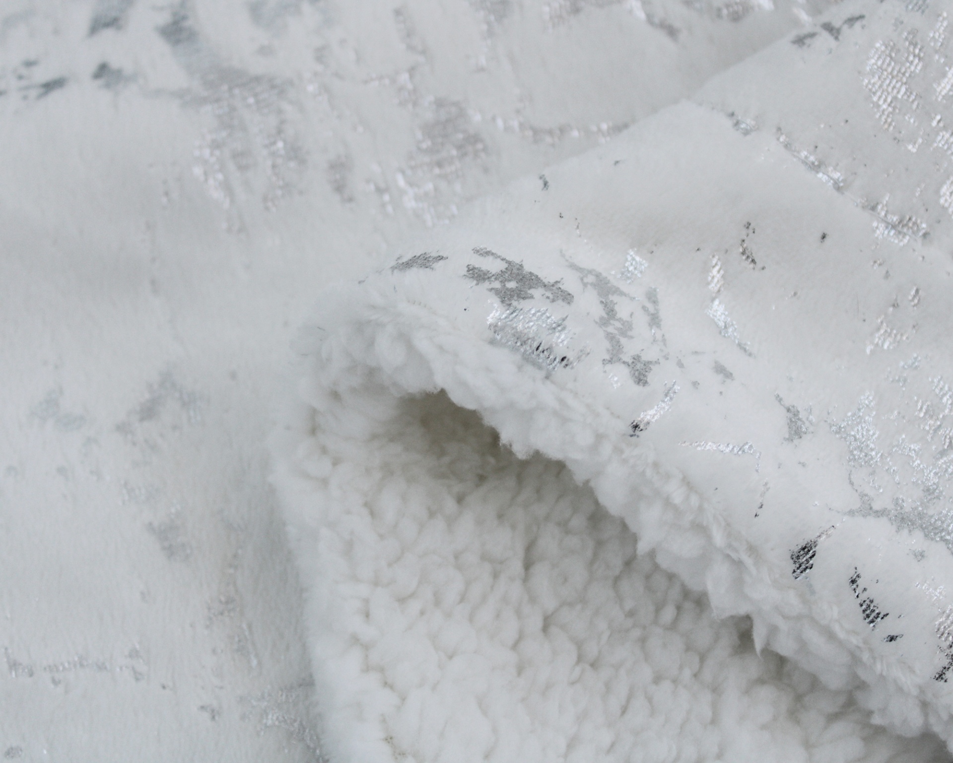 tecido branco com padrão metálico prateado e interior felpudo