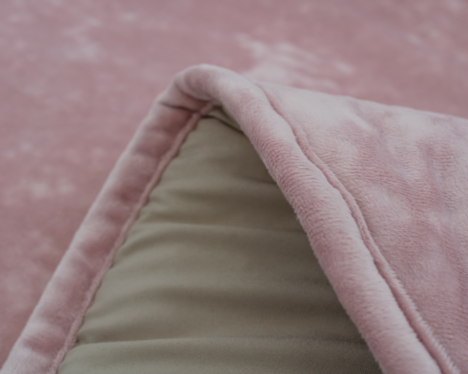 Tapete felpudo rosa com textura aveludada e borda almofadada dobrado