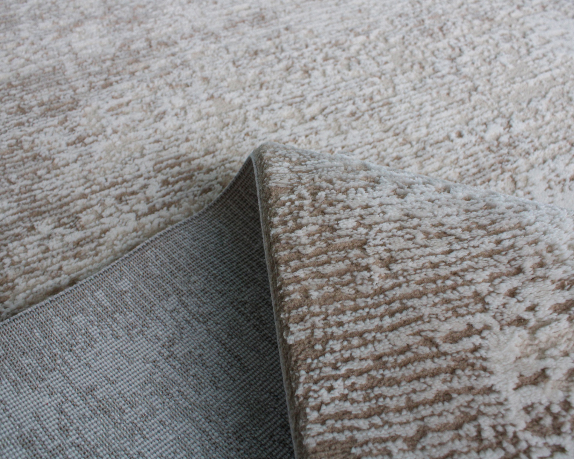 Tapete bege com padrão irregular e verso cinzento