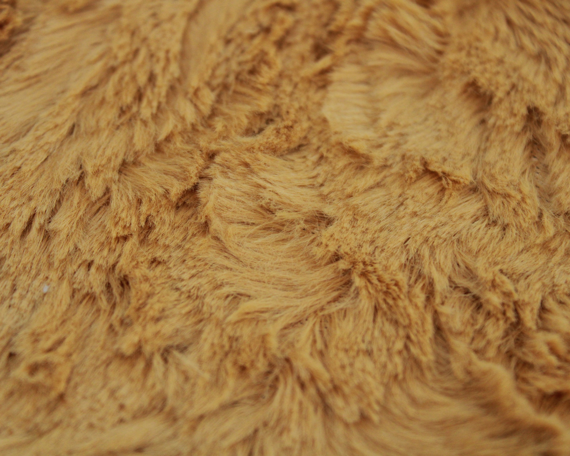 Tecido felpudo cor de mostarda com textura macia.