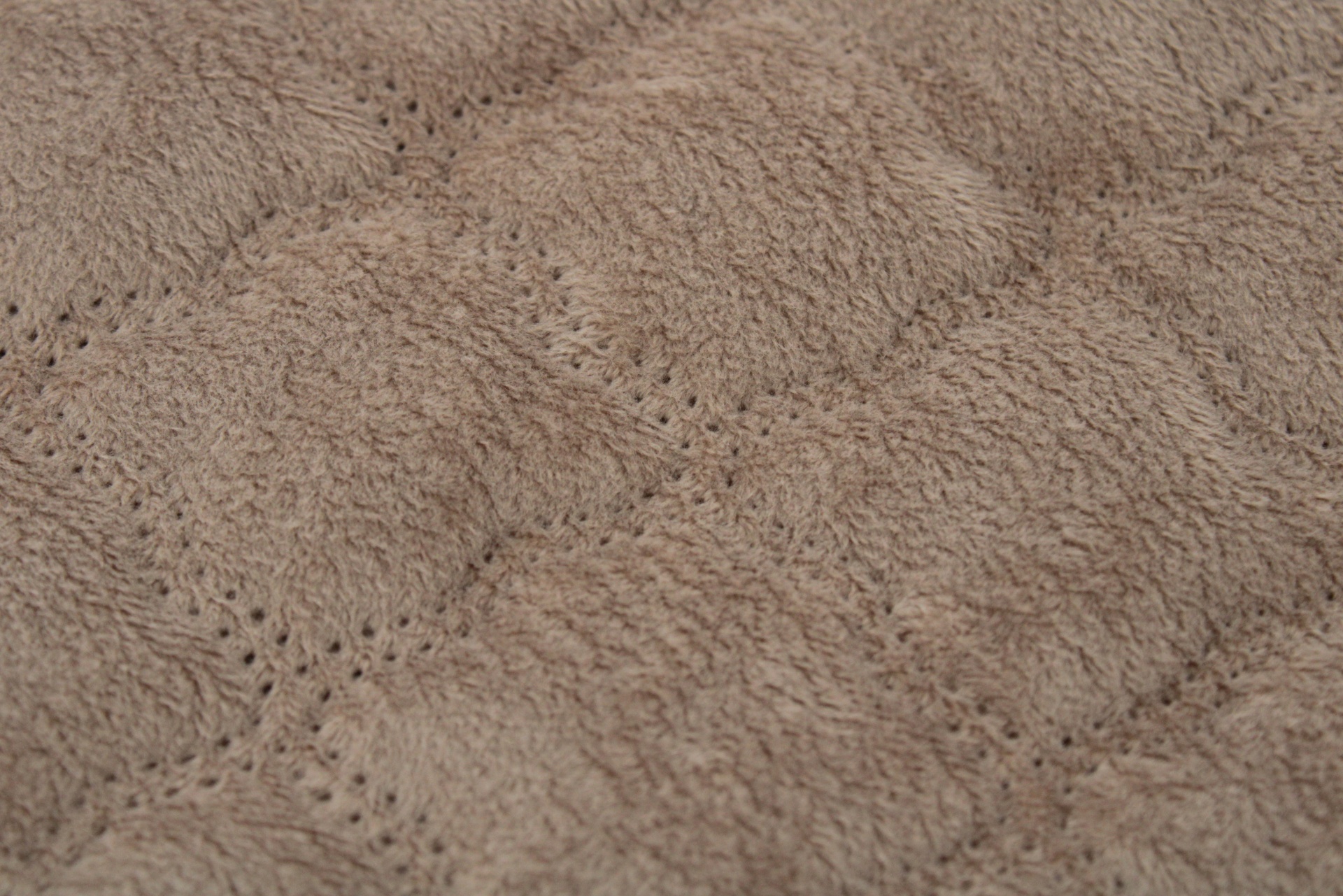 Tecido castanho claro aveludado com padrão de pontos perfurados