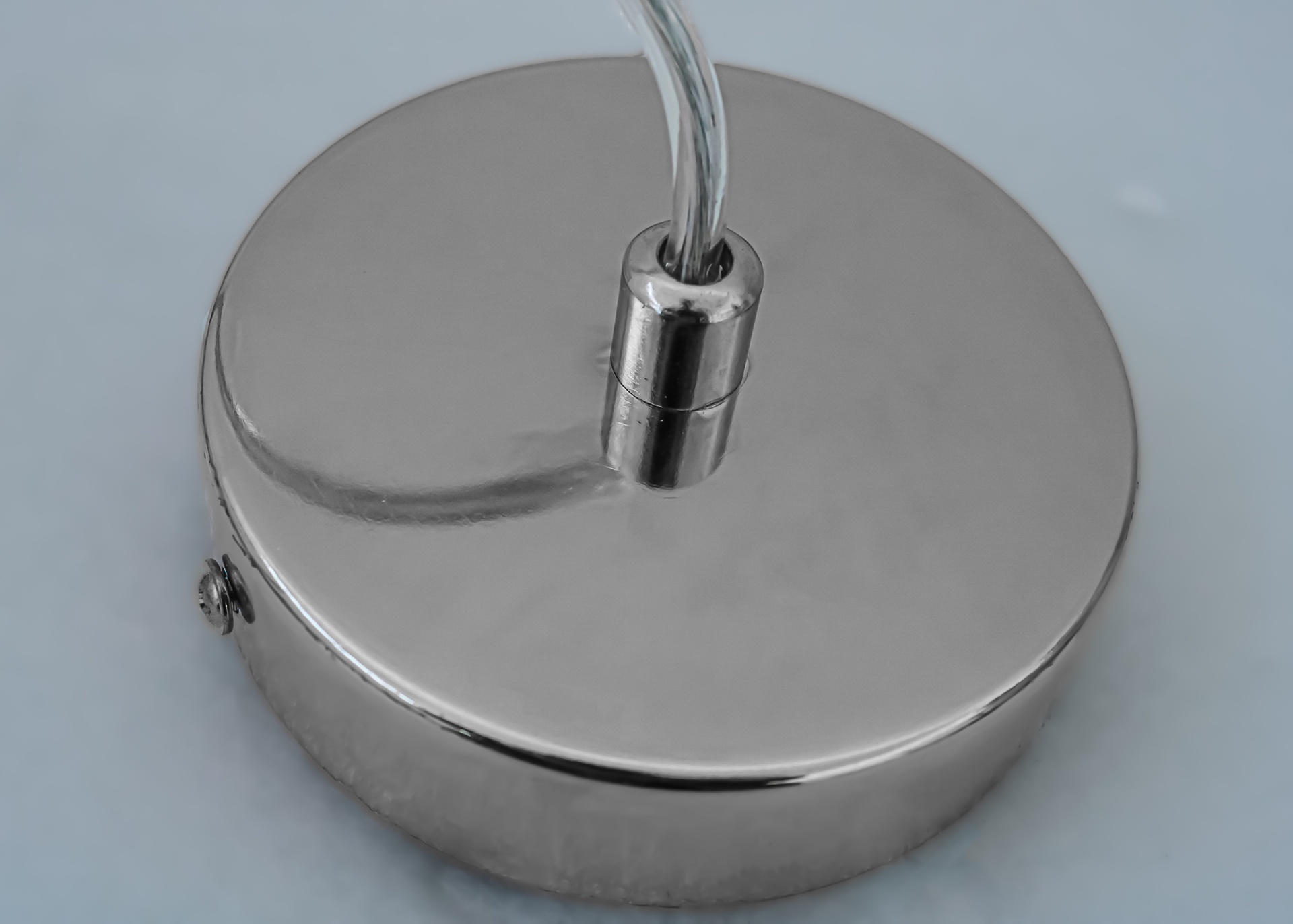 Base redonda de metal prateado com cabo ligado no centro