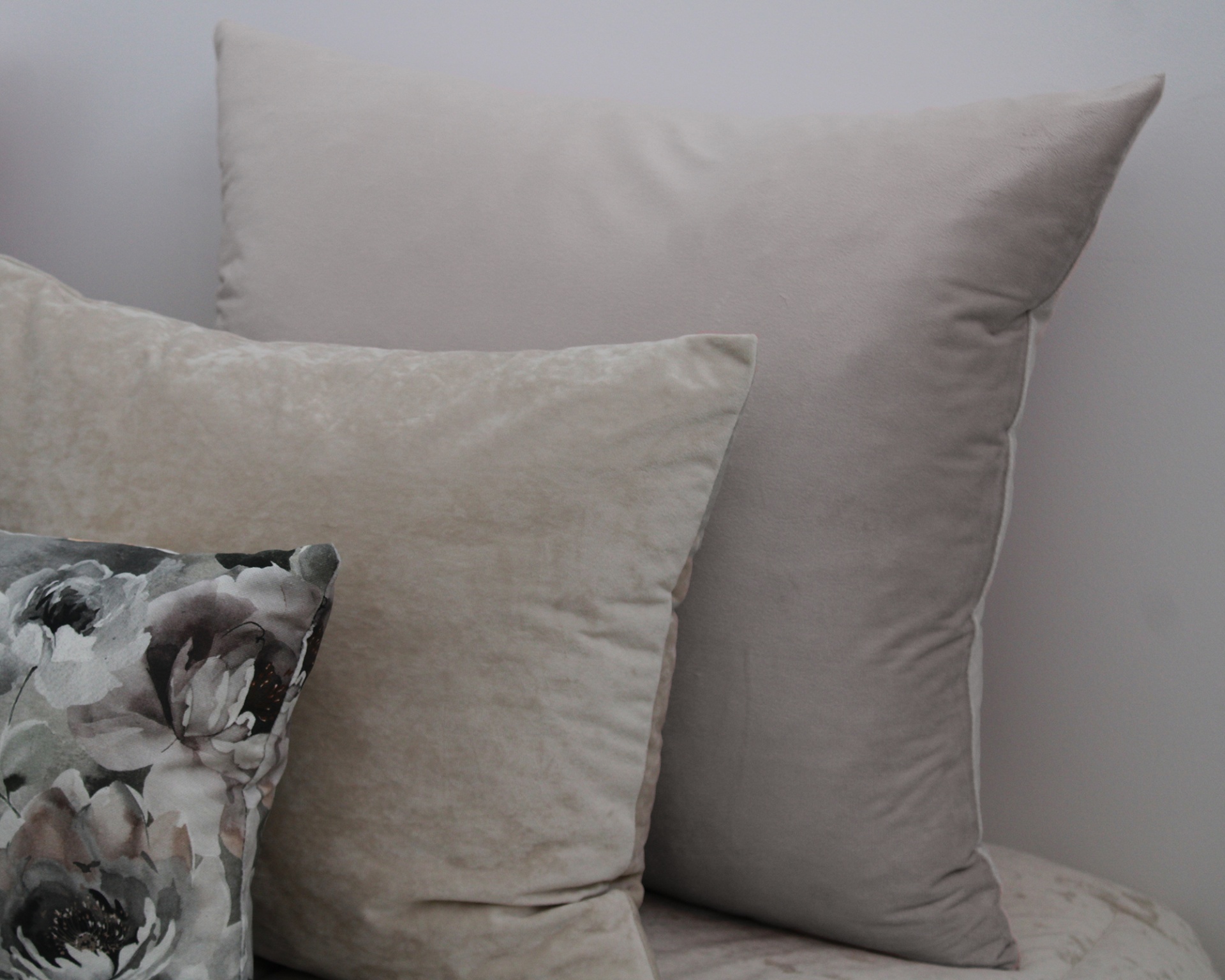Três almofadas decorativas em tons neutros e floral