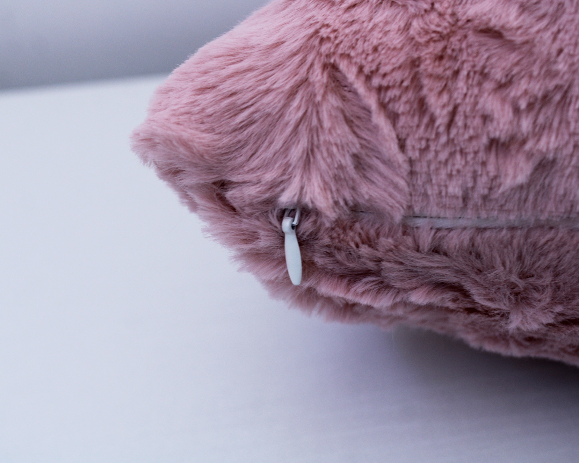 Detalhe de tecido rosa felpudo com fecho de correr branco