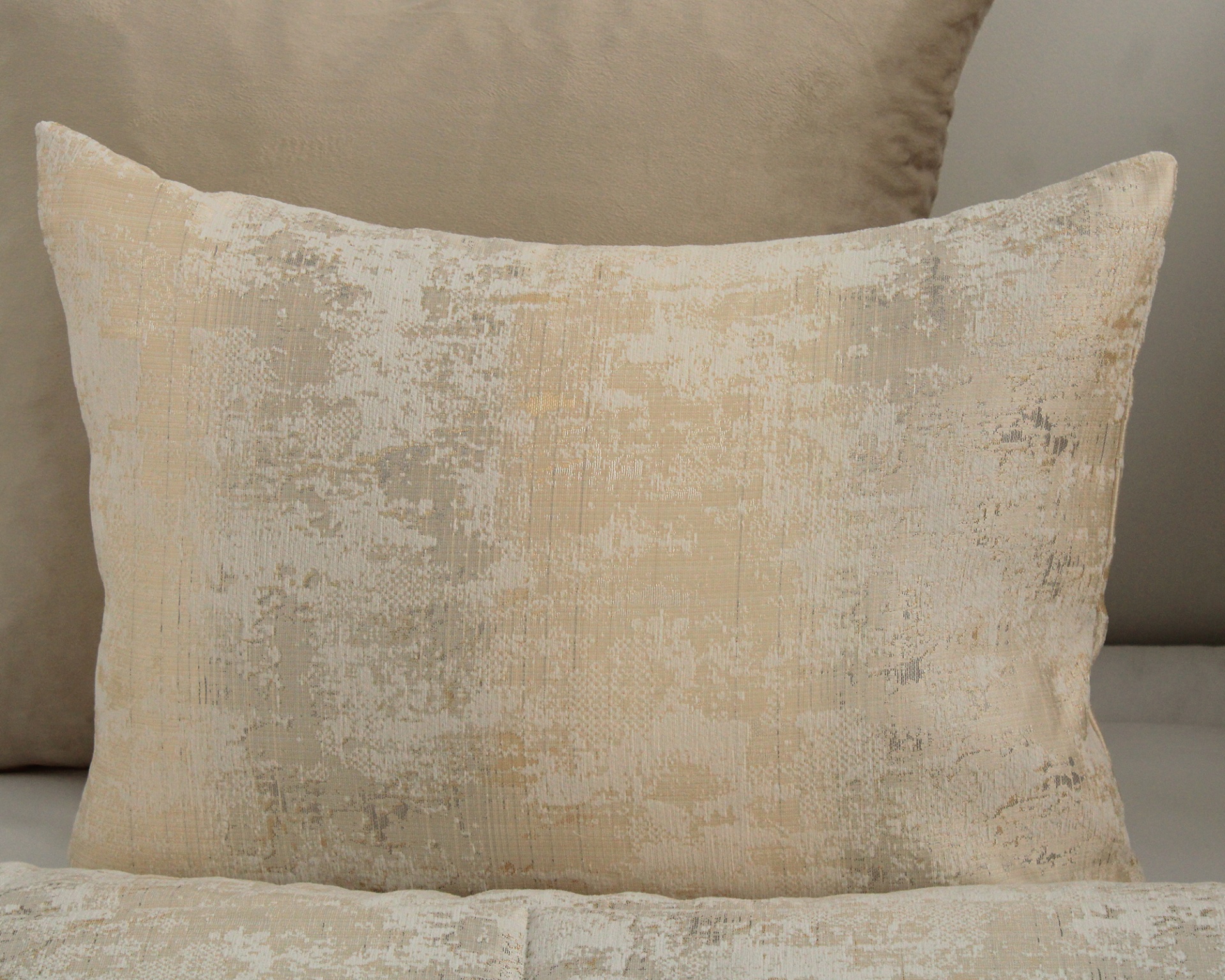 Almofada retangular com padrão abstrato em tons neutros