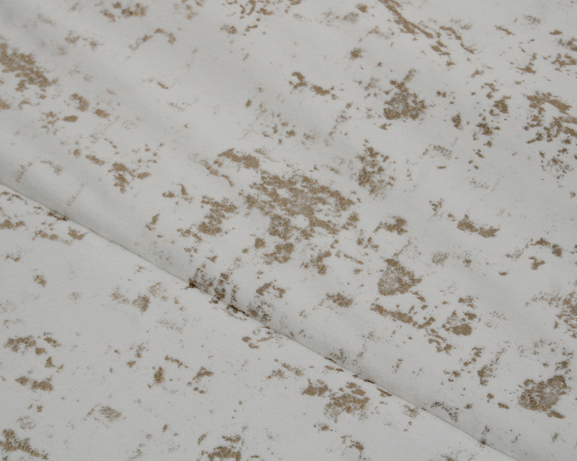 Tecido branco com padrão castanho claro e dobra visível