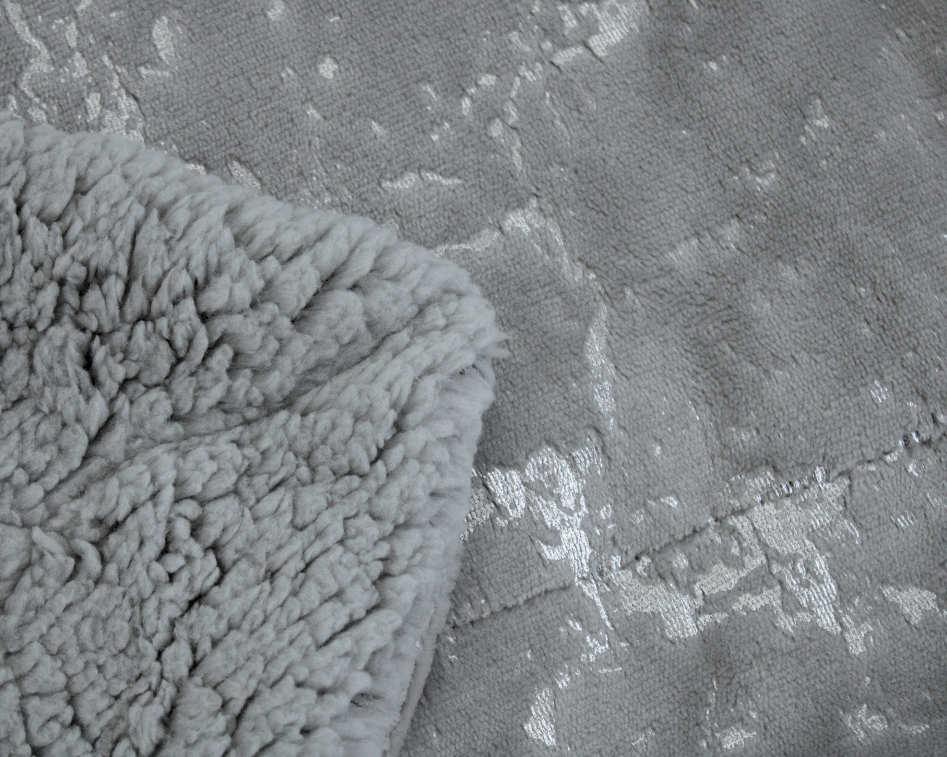 Tecido cinzento com padrões brilhantes prateados e tecido felpudo cinzento