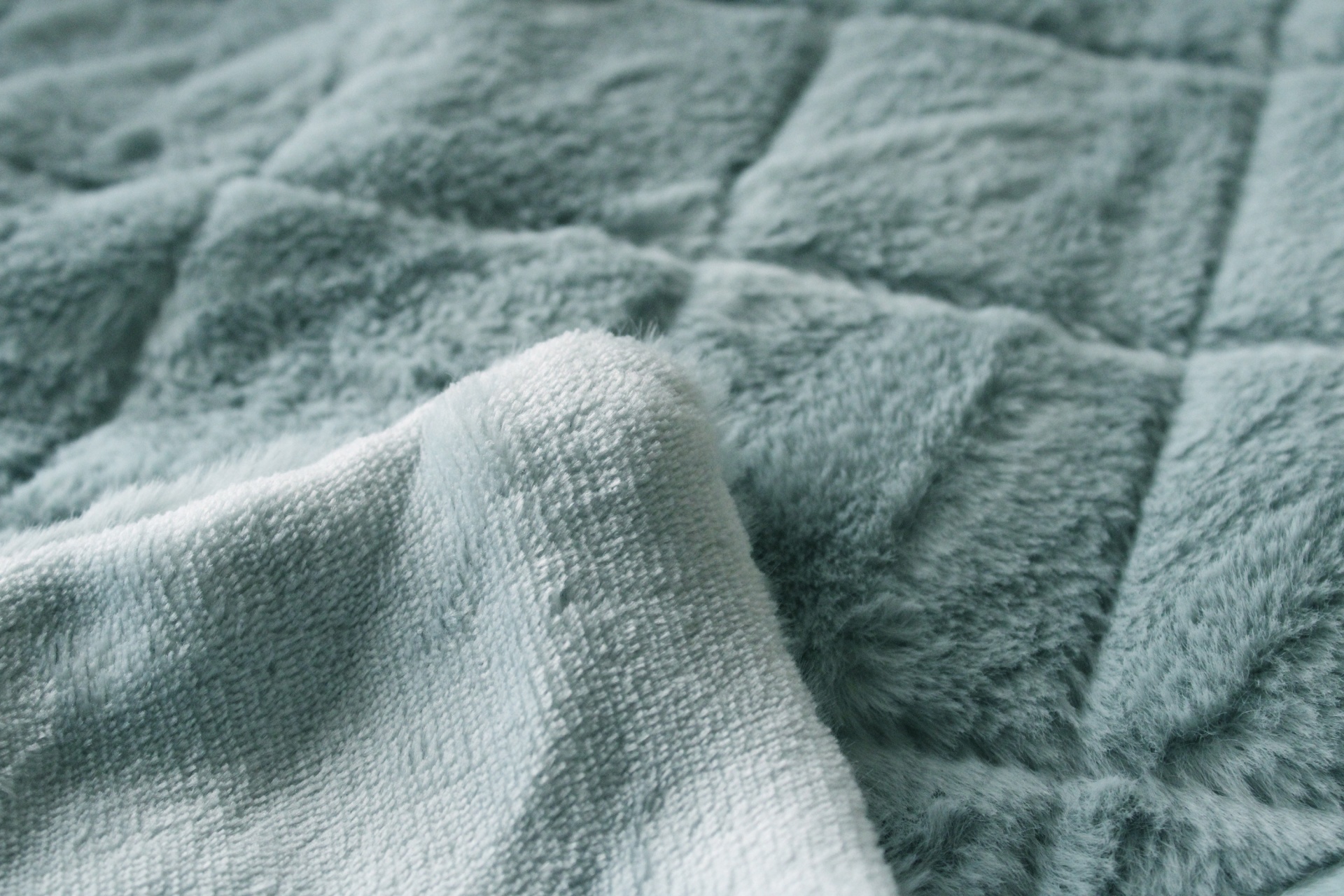 Cobertor ou manta cinza claro com padrão quadriculado e textura peluda