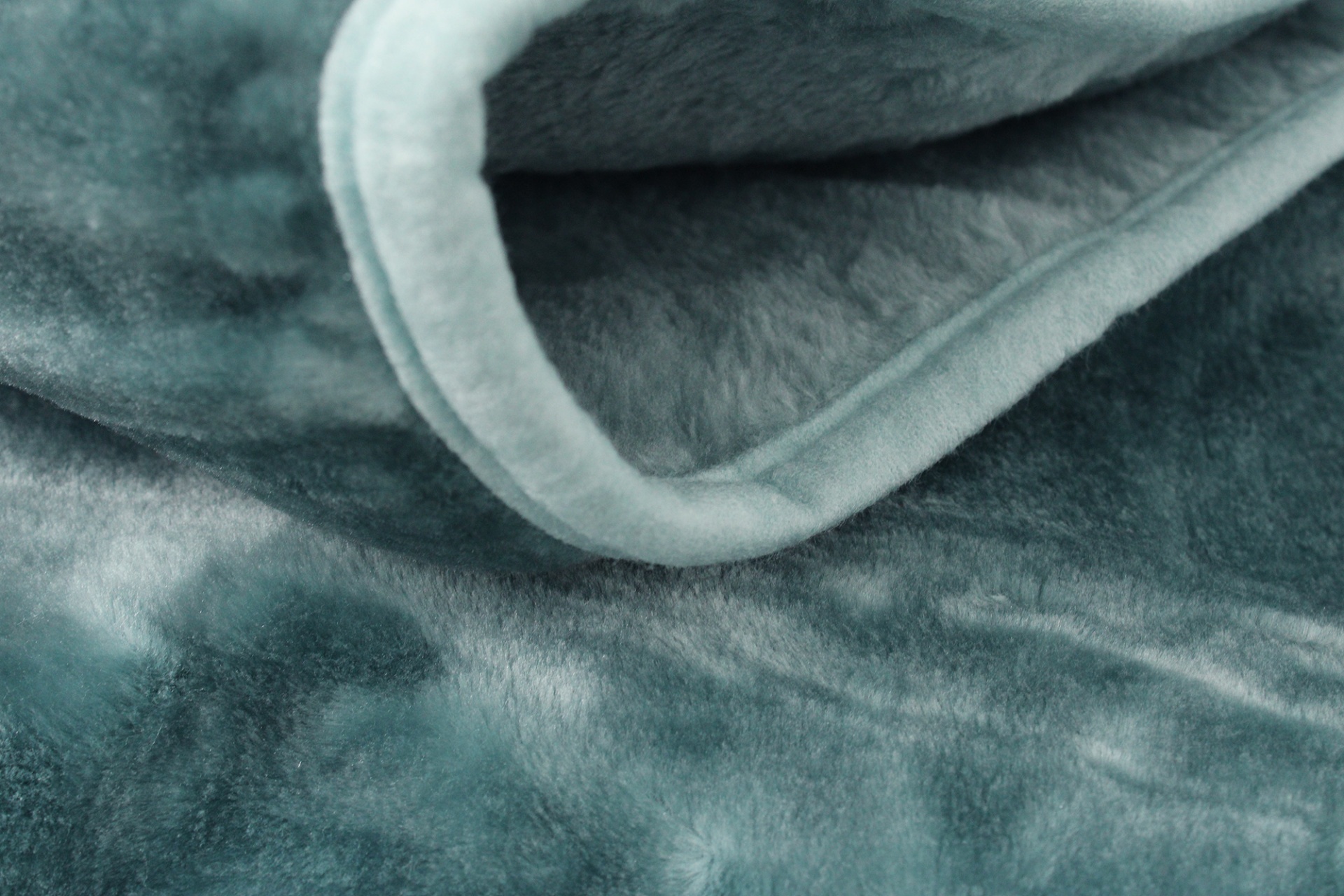 Manta azul-esverdeada felpuda dobrada