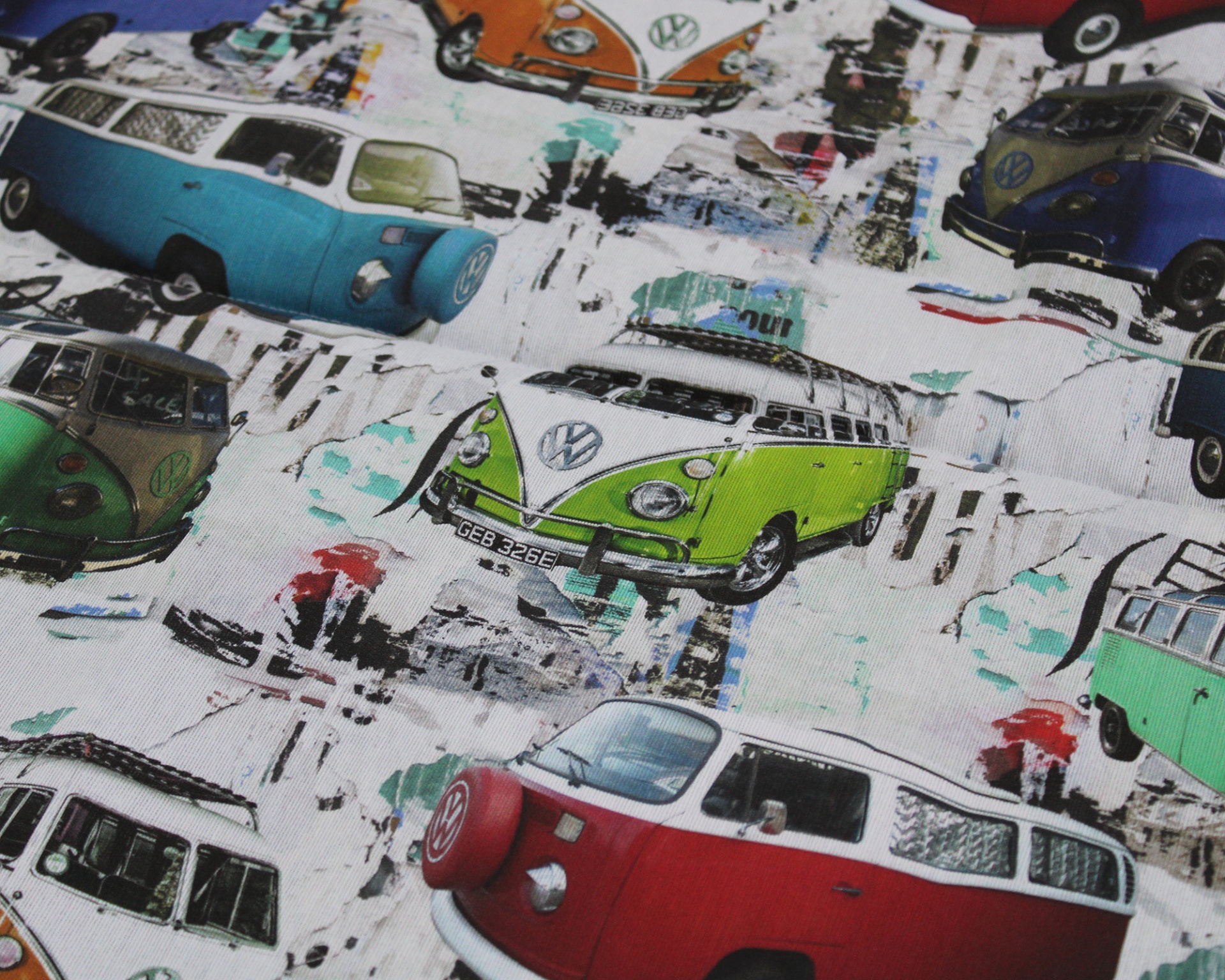 Tecido com padrão de carrinhas Volkswagen coloridas em fundo branco