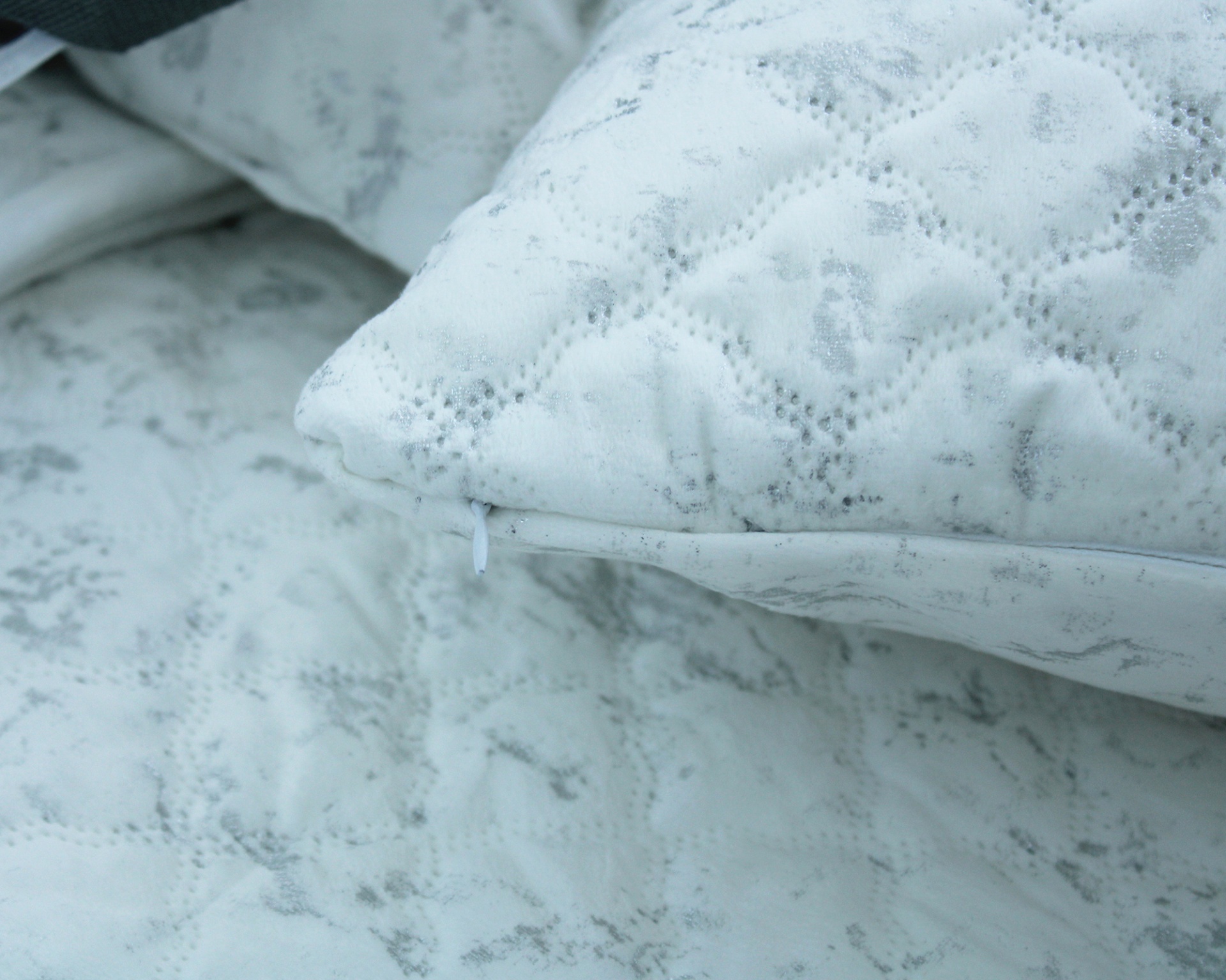 Almofada branca com padrão floral cinzento e fecho de correr