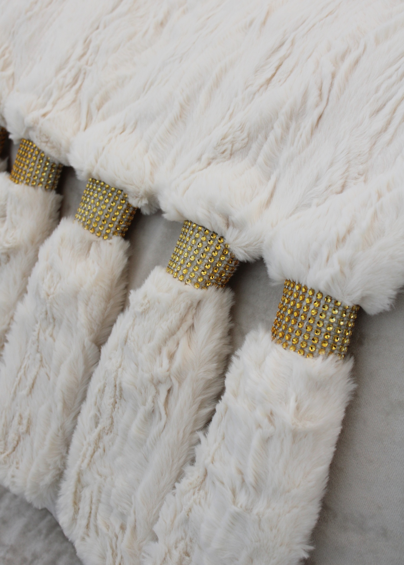 Acessórios de pele branca com bandas douradas e pedras brilhantes