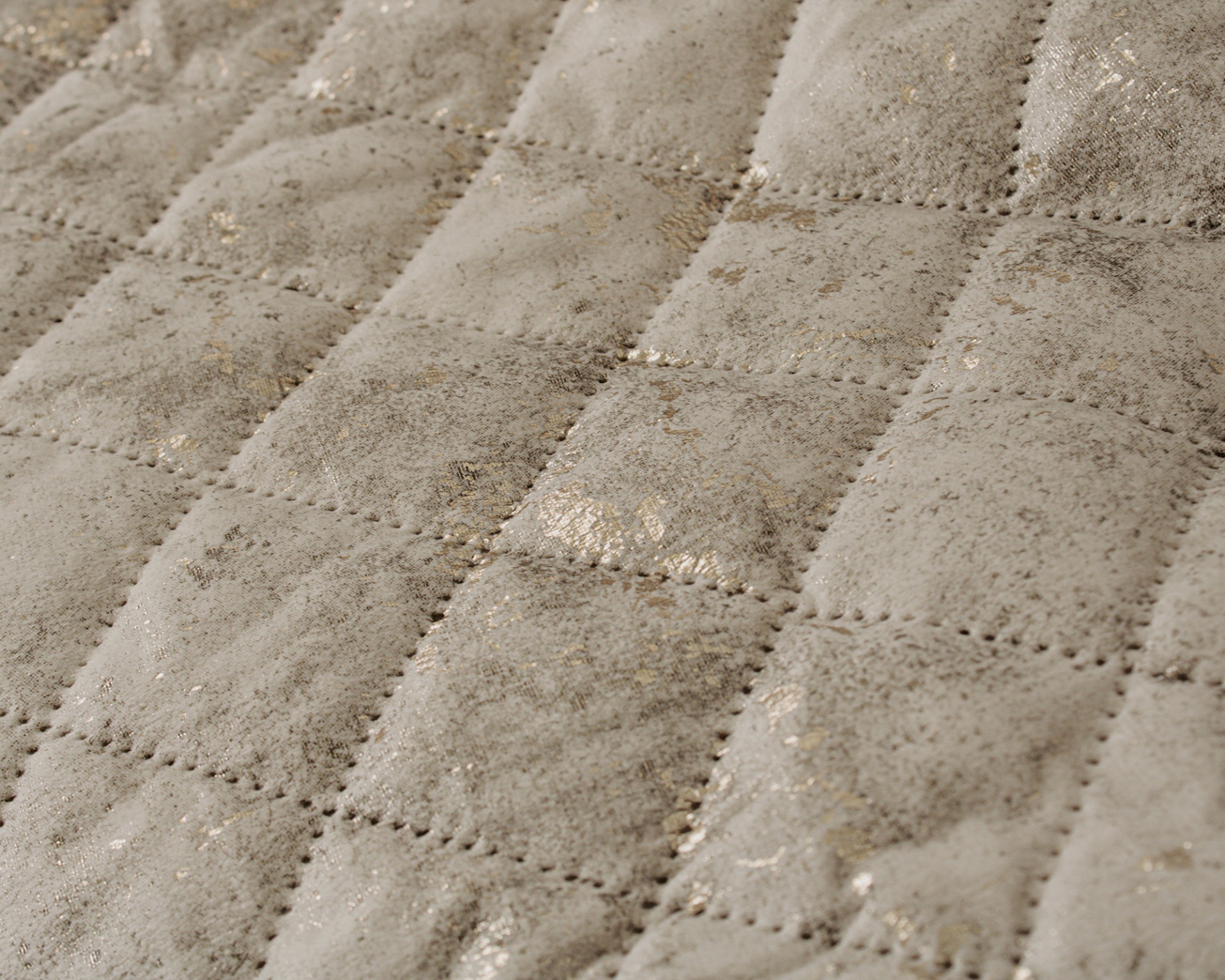 Tecido acolchoado bege com padrão de quadrados e pontos perfurados