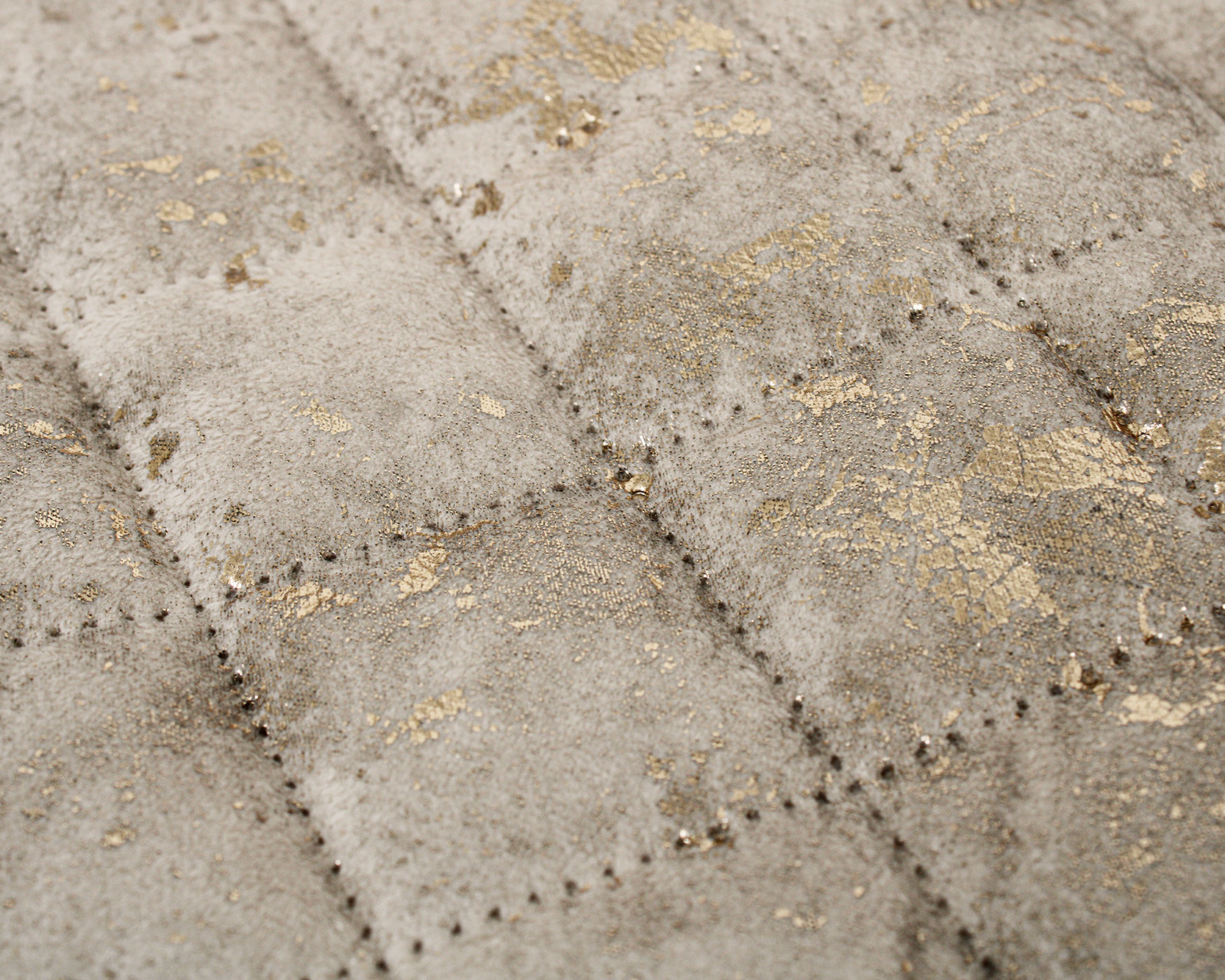 tecido cinza acolchoado com manchas douradas e padrão de quadrados