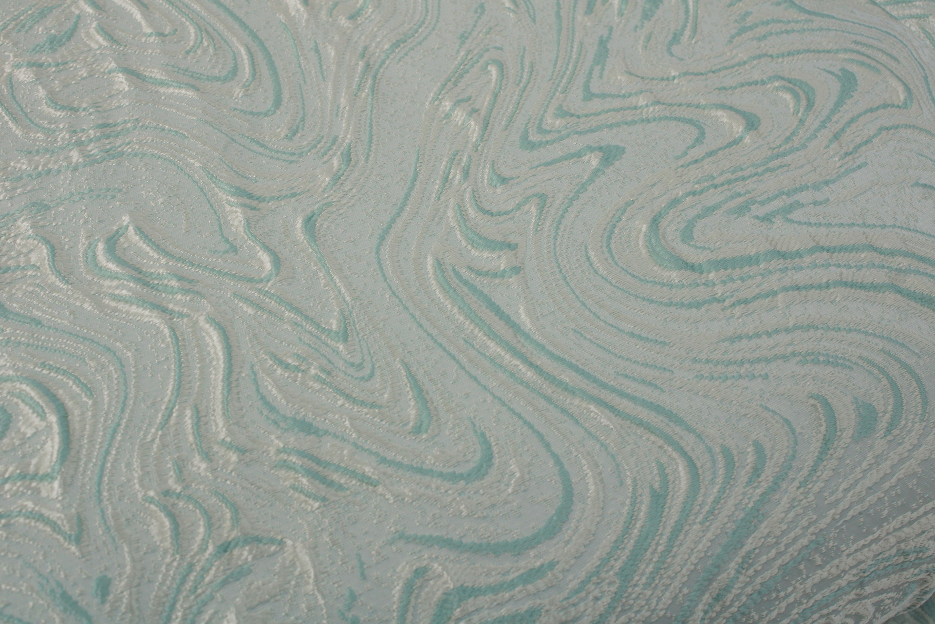 Tecido decorativo cinza com padrão ondulado azul esverdeado