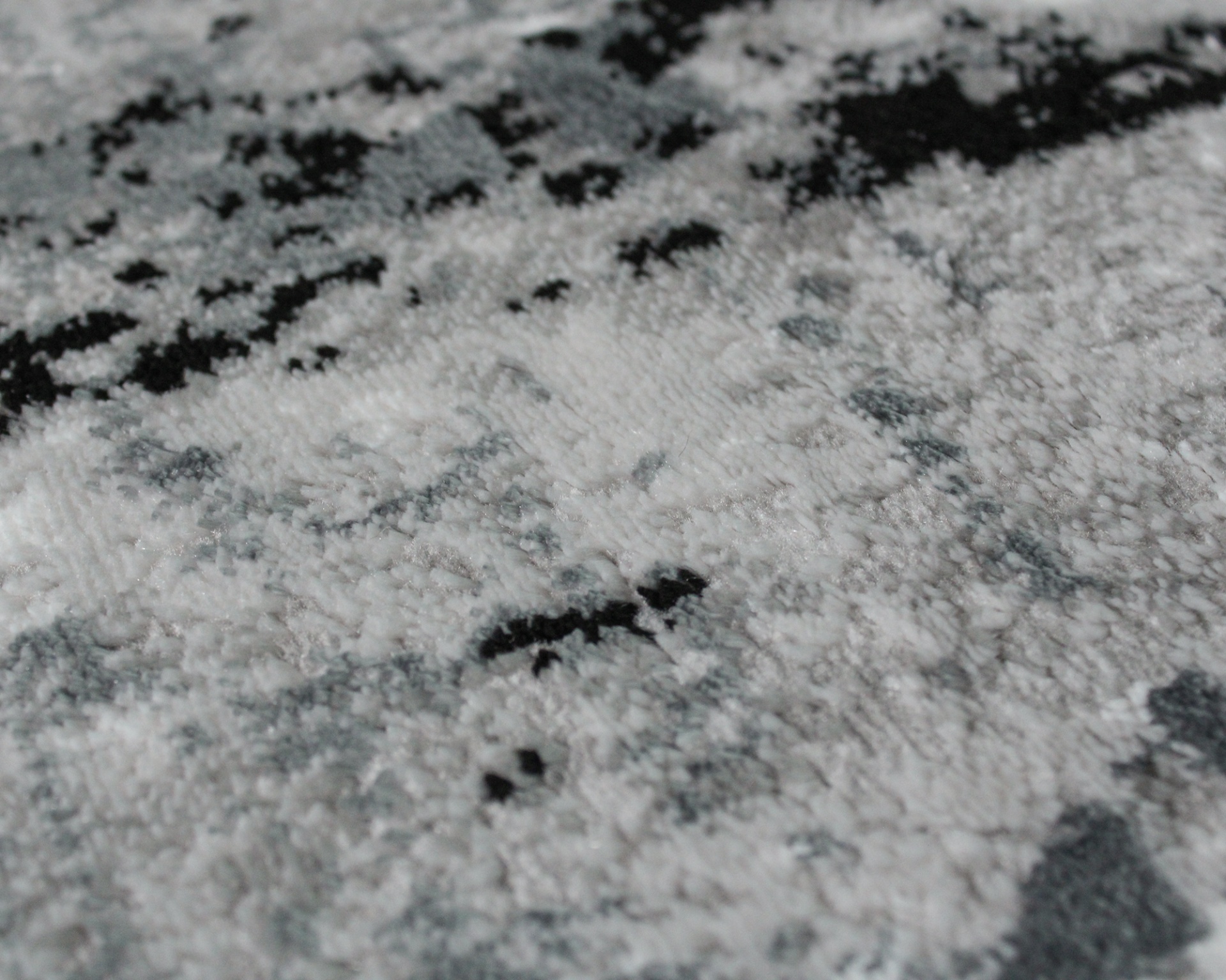 Tapete felpudo cinza, preto e branco com padrão abstrato