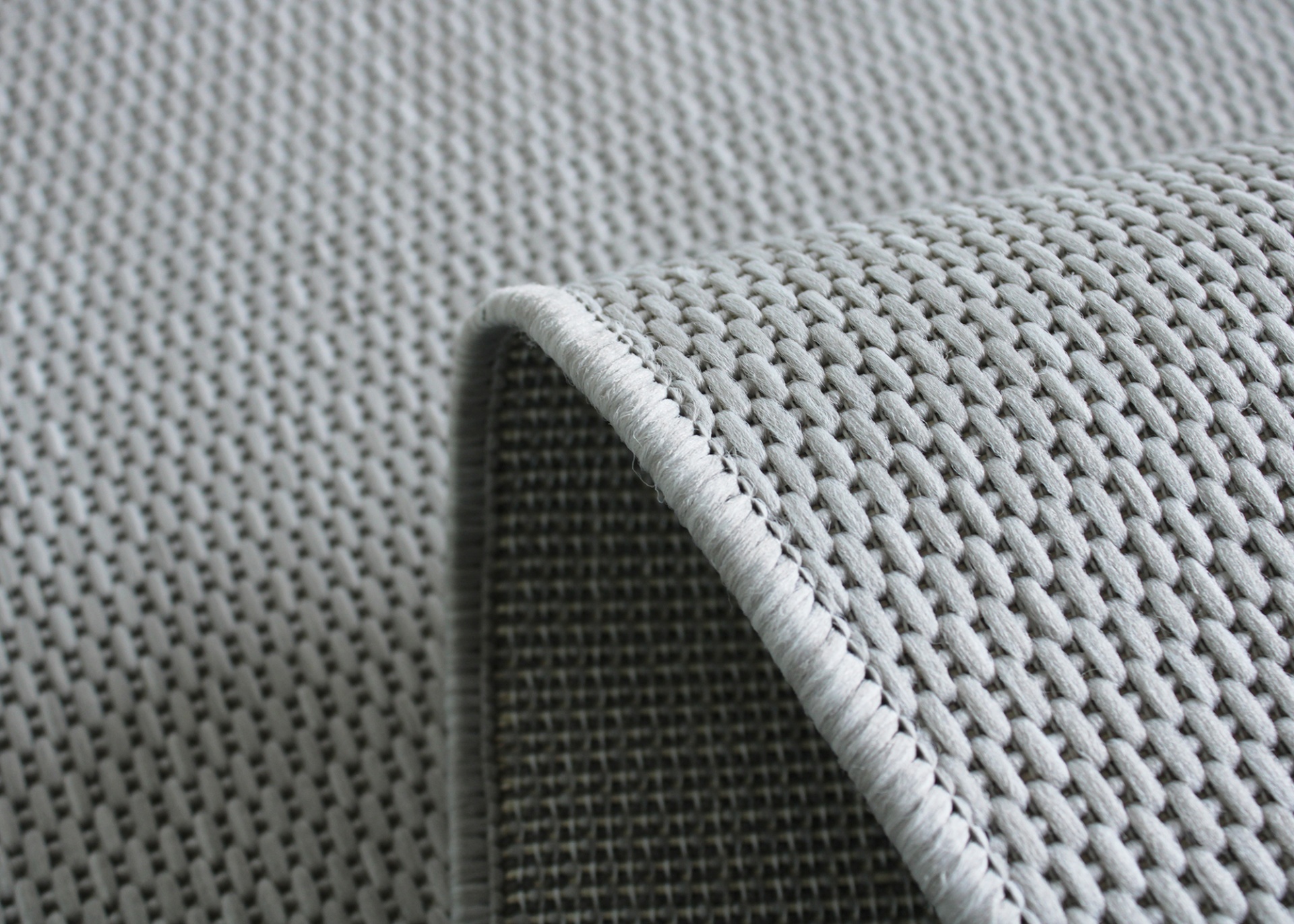 Tecido cinza claro em malha entrelaçada com borda costurada reforçada