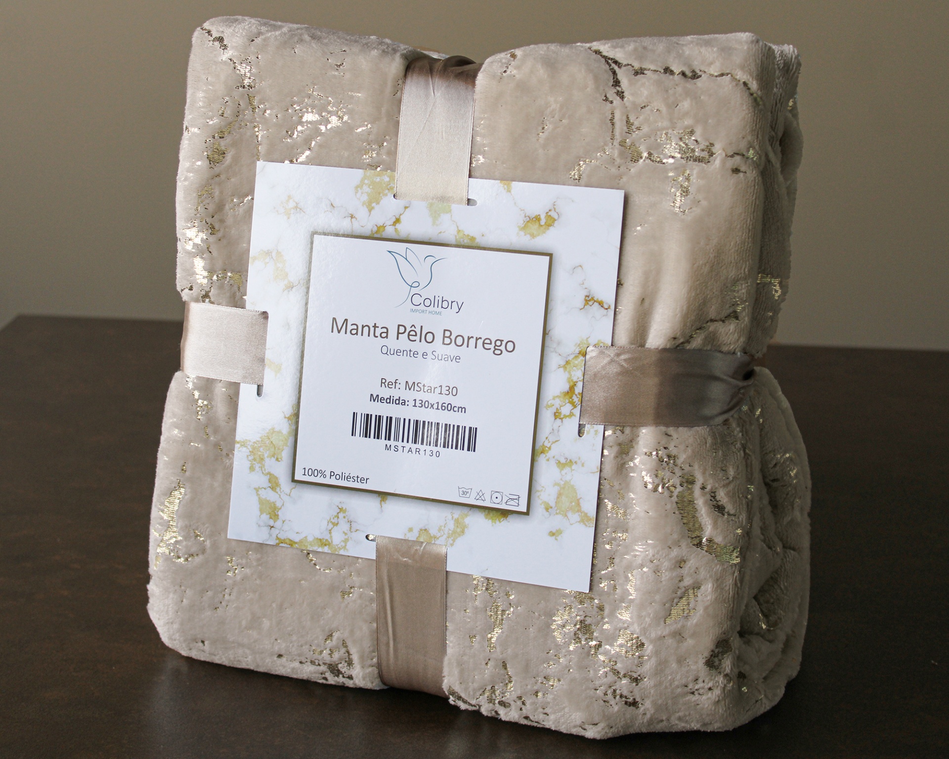 Manta bege com padrão dourado e etiqueta Colibry