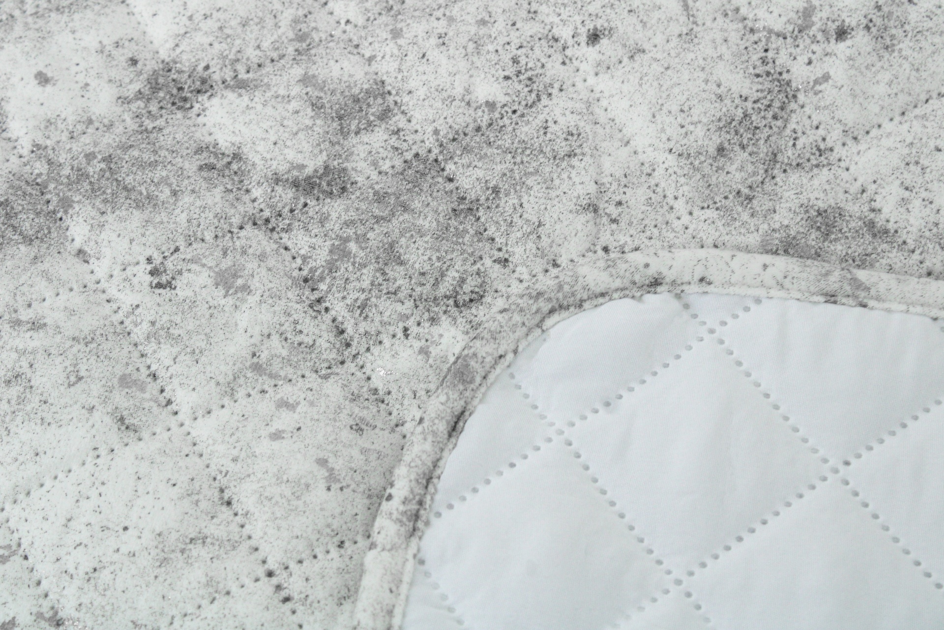tecido branco acolchoado com manchas pretas
