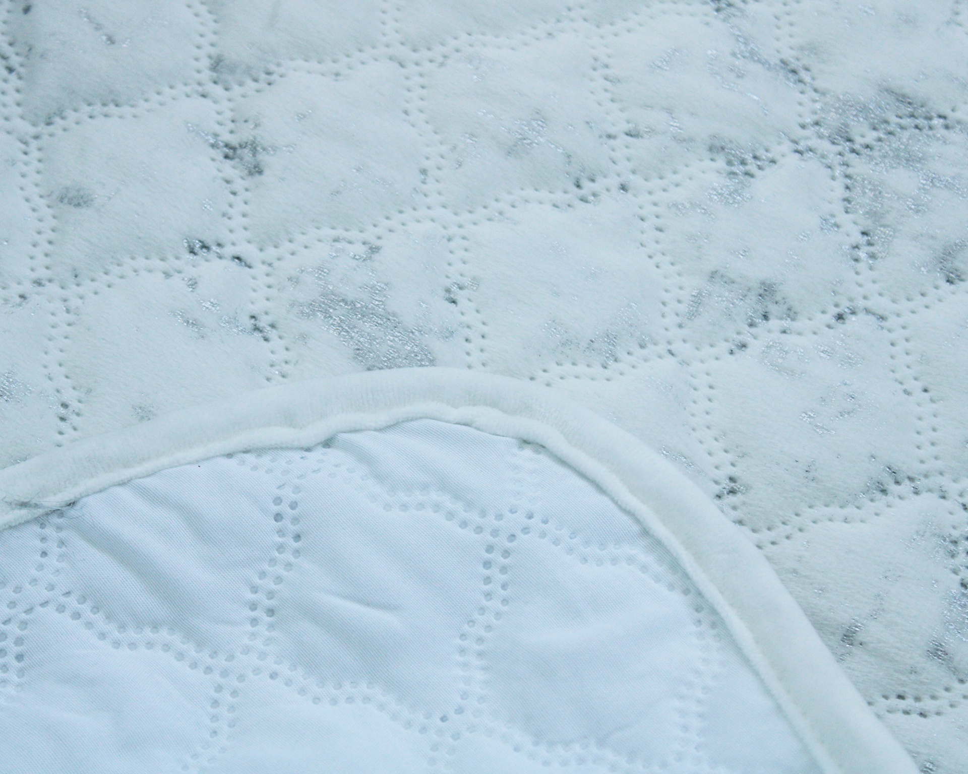 Protetor de colchão branco acolchoado com padrão floral e losangos