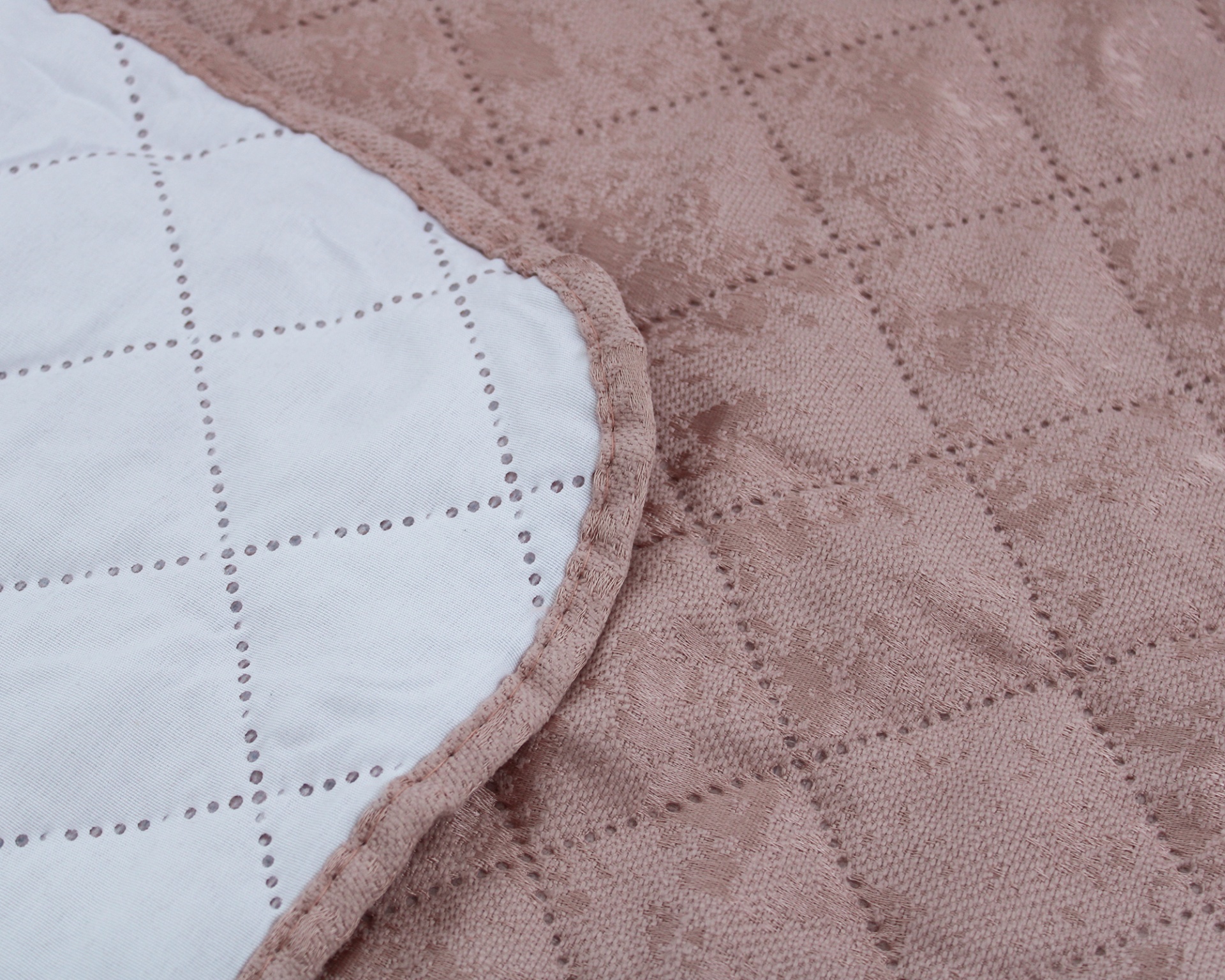 Cobertor acolchoado bicolor com padrão floral e quadriculado.