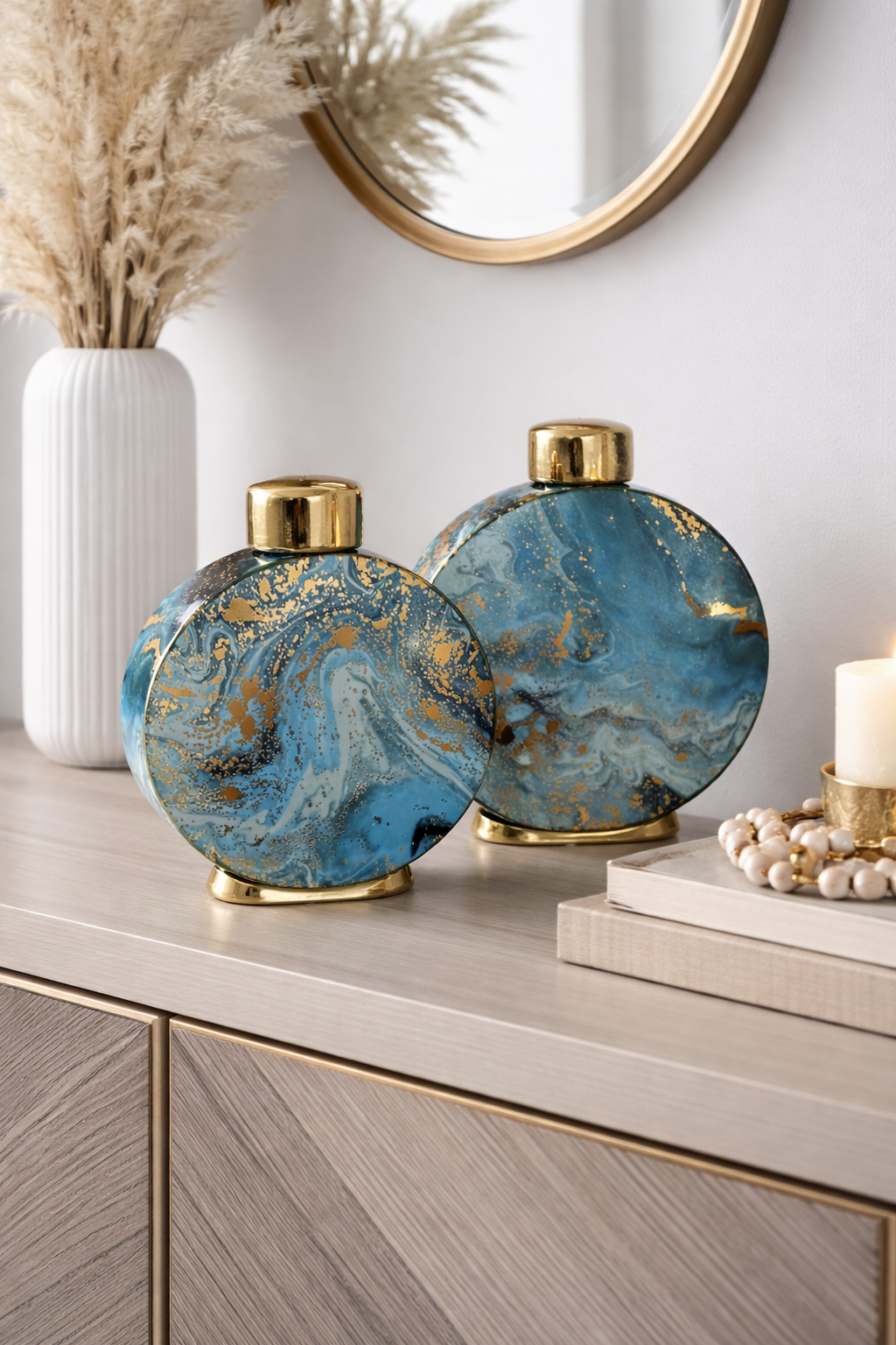Dois jarros decorativos redondos azul marmoreado com detalhes dourados em móvel de madeira