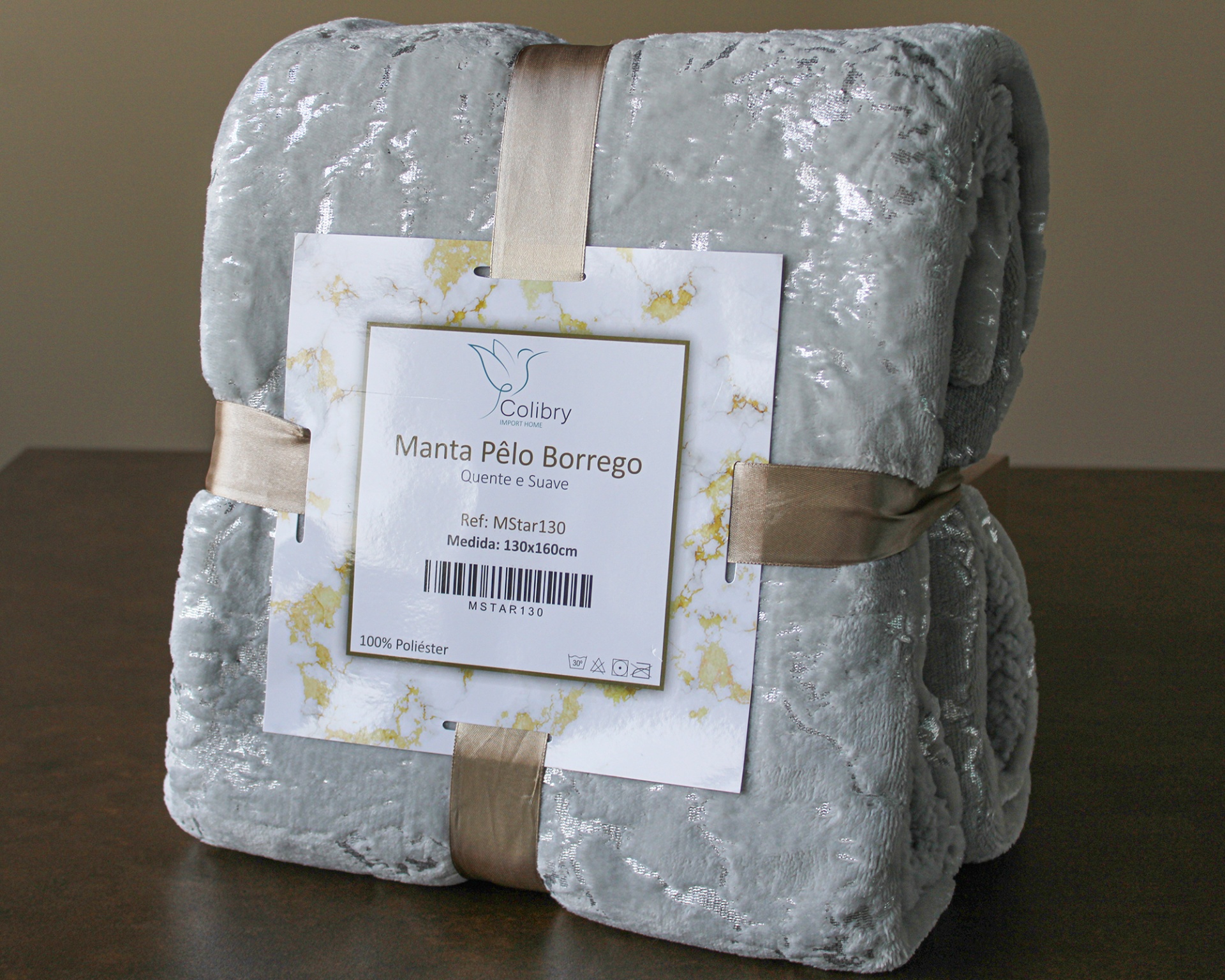 Manta cinza claro aveludada com etiqueta branca e fita bege