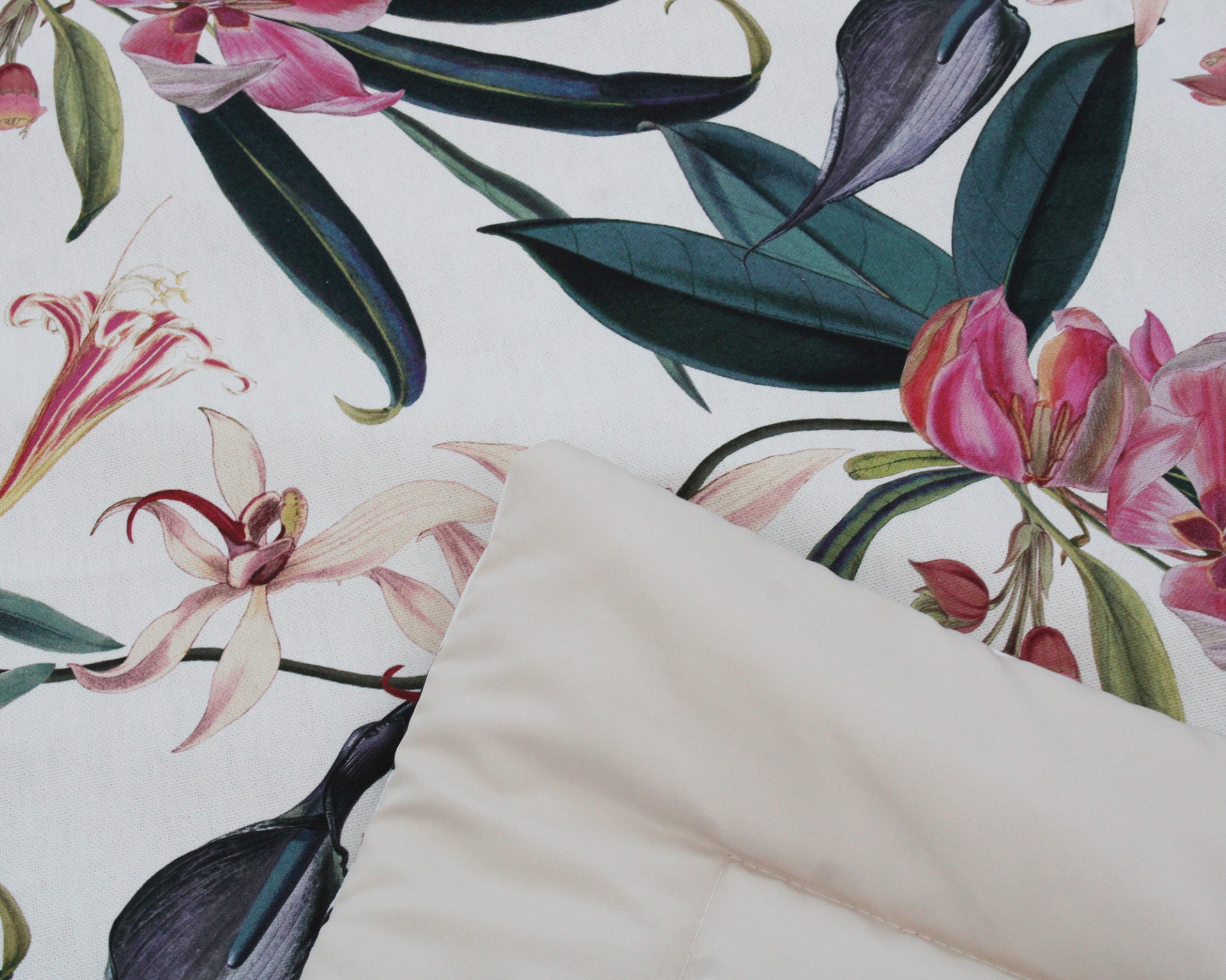 Tecido com padrão floral colorido e almofada creme em tecido liso.