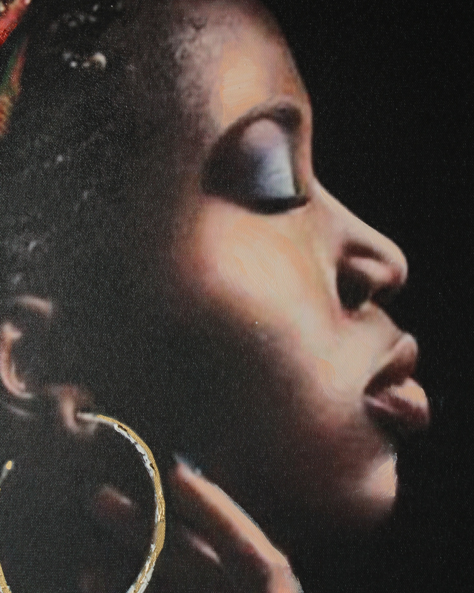 Retrato de perfil de mulher negra com maquilhagem azul e brinco dourado